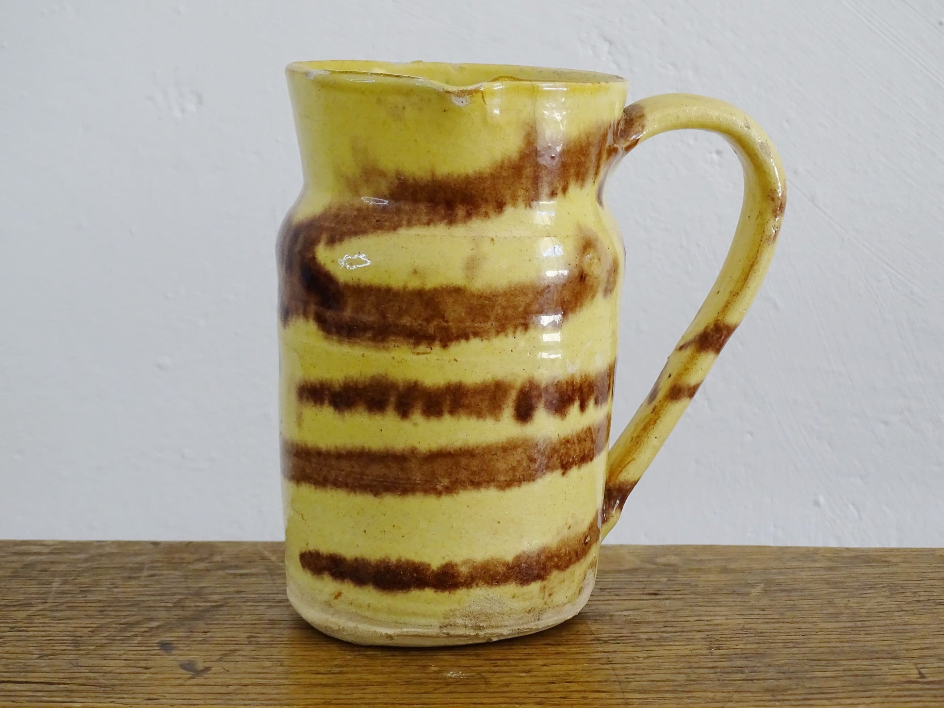 French antique ceramic jug from Dieulefit with a yellow glaze with brown drip glaze stripe.