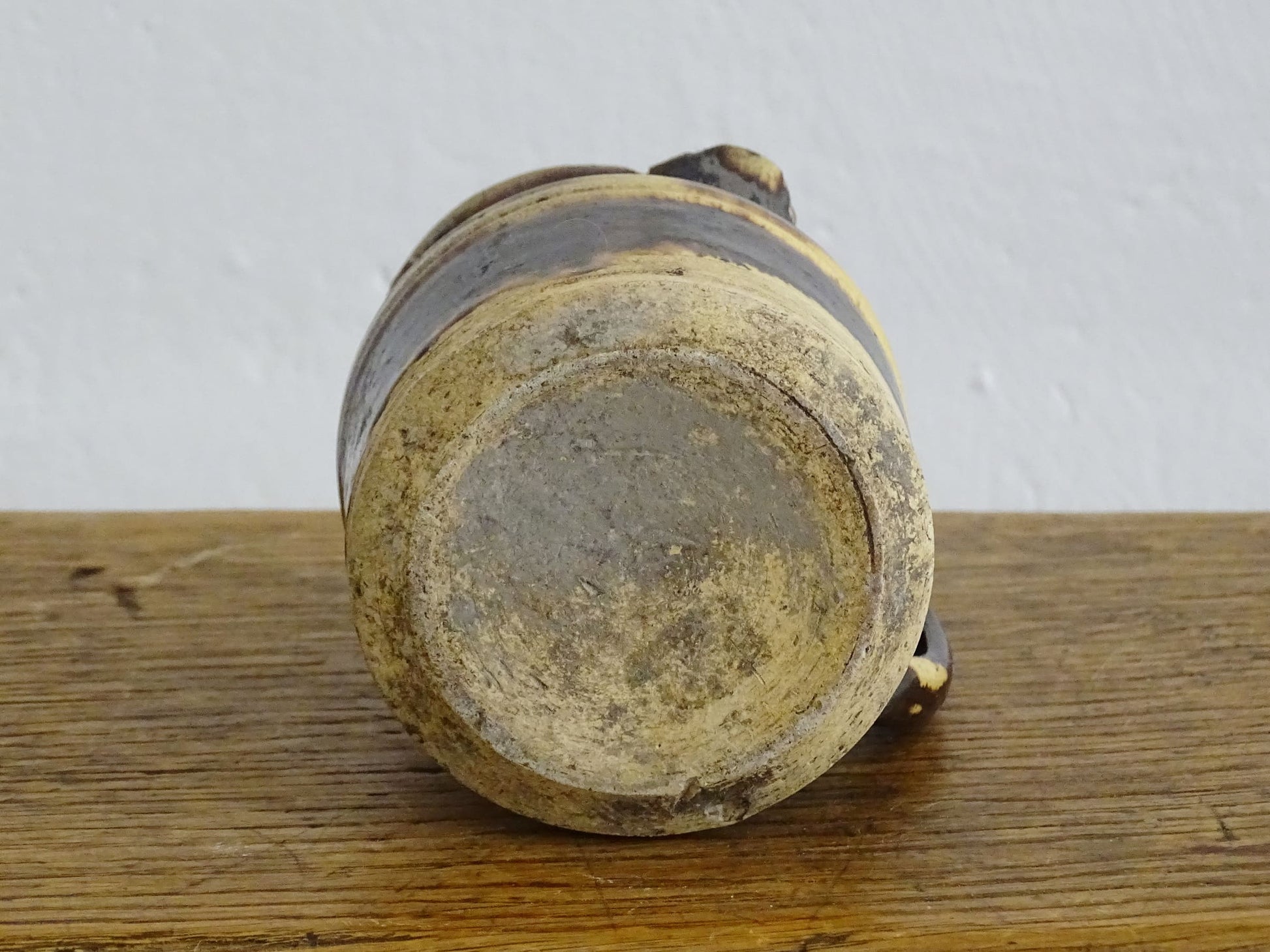 French antique ceramic jug from Dieulefit with brown drip glaze and yellow glazed background.