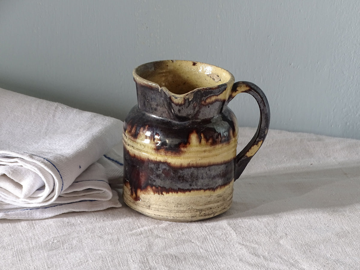 French antique pottery pitcher with yellow and brown glaze