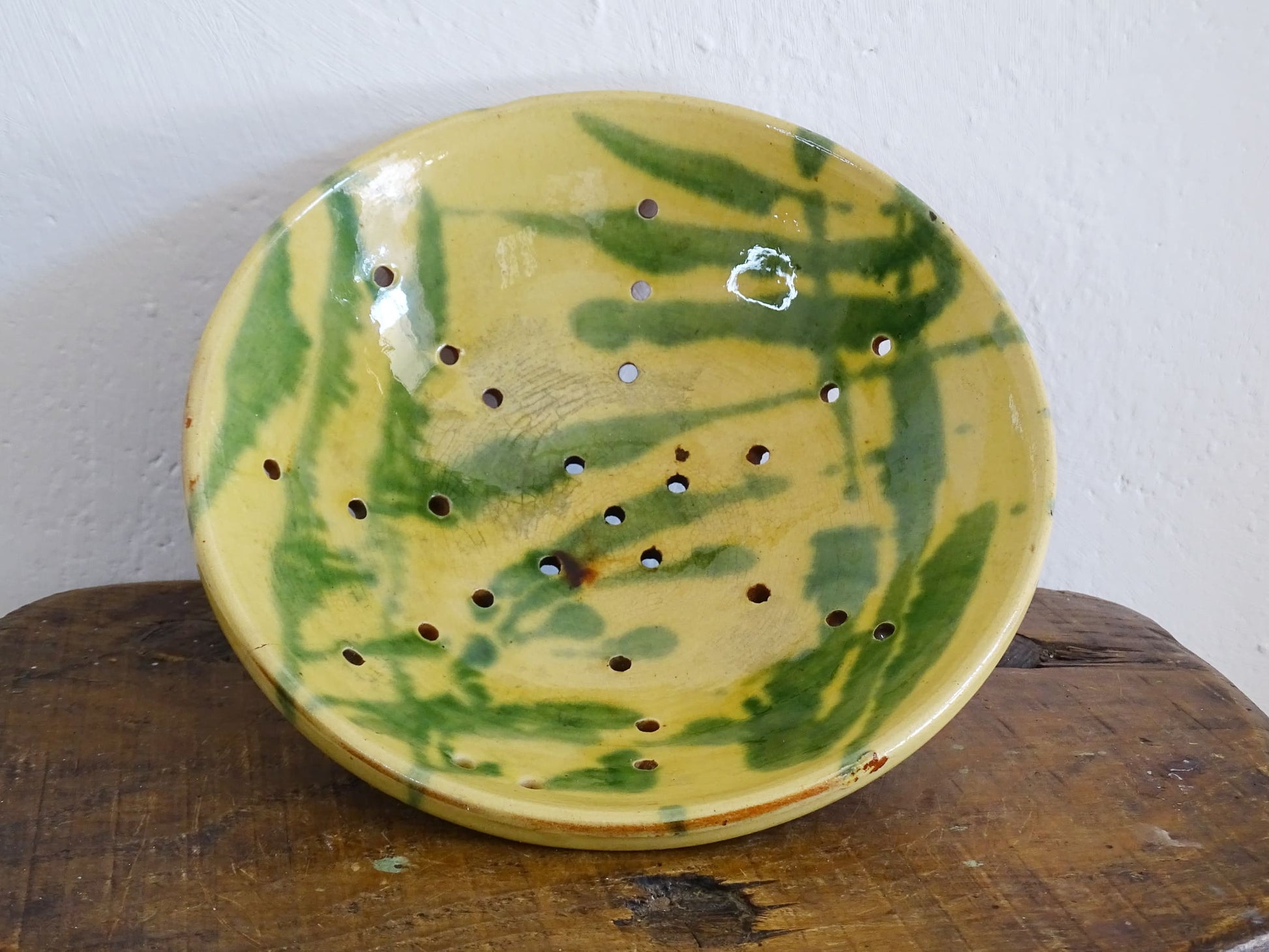 French antique ceramic colander with a yellow and green glaze. Pottery colander for berries. 