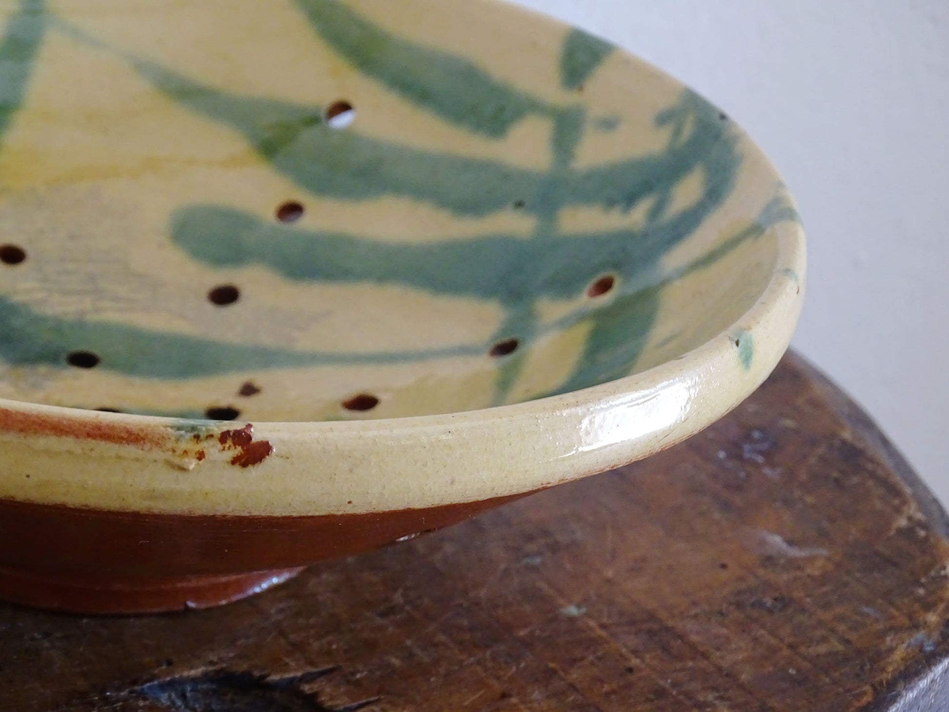 French antique ceramic colander with a yellow and green glaze. Pottery colander for berries. 