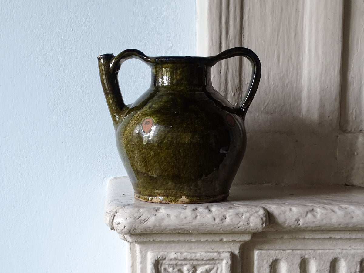 French antique earthenware jug or orjol with a green glaze, displayed on a country house fireplace