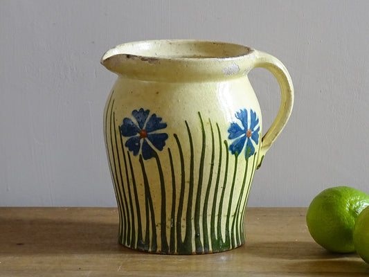 French antique pottery jug with hand painted flowers. Yellow glazed pitcher with blue flowers for a French farmhouse or cottagecore kitchen. 