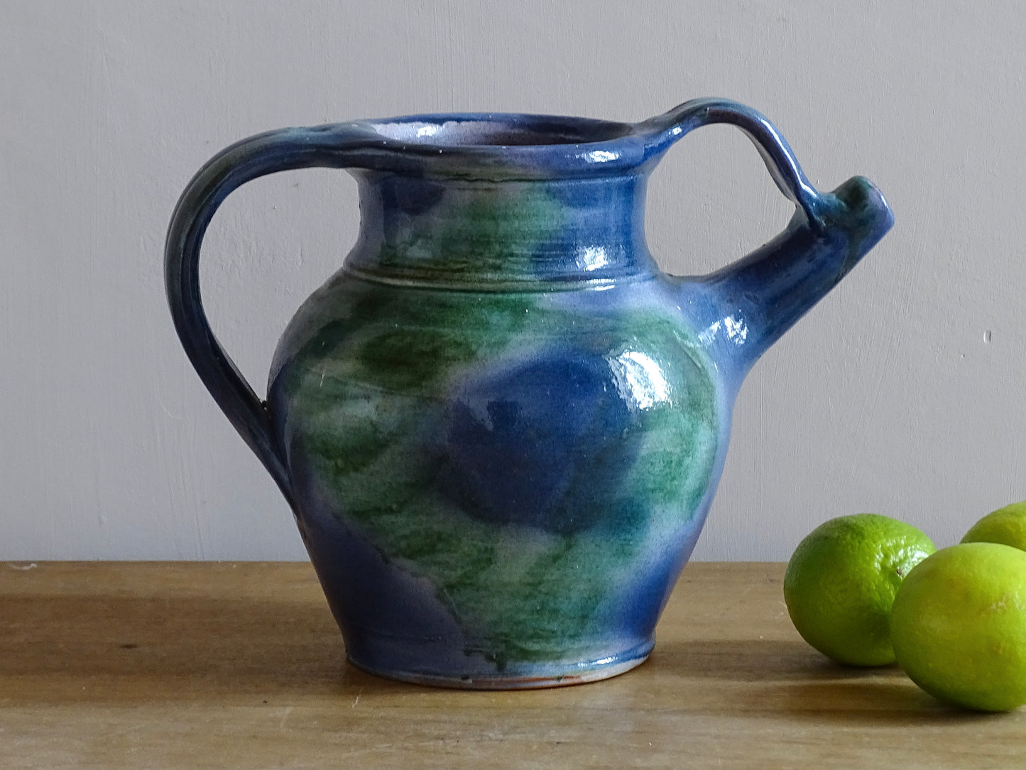 French vintage pottery jug or orjol with a soft blue and green glaze. Glazed terracotta water jug with spout and handle. 