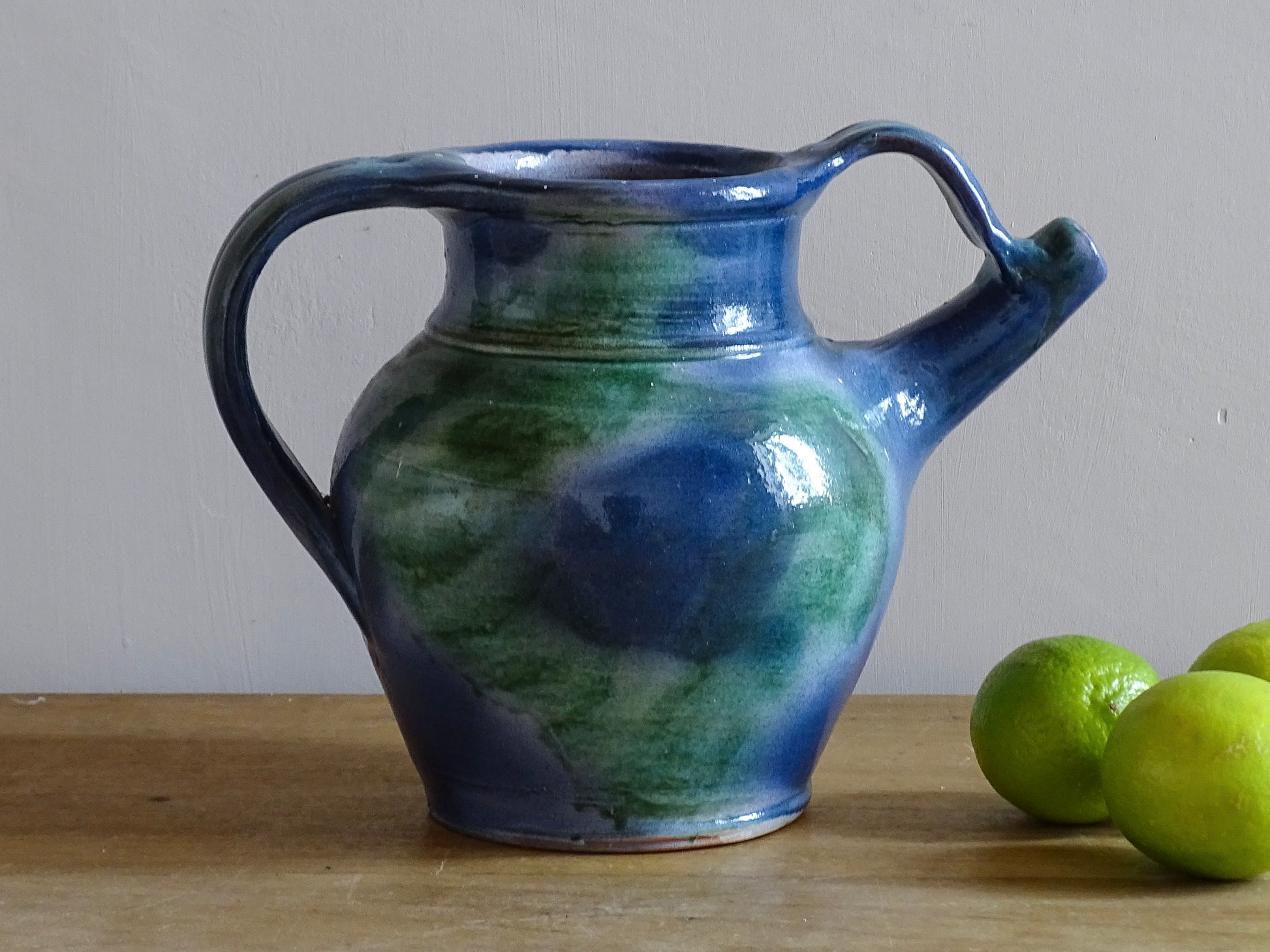 French vintage pottery jug or orjol with a soft blue and green glaze. Glazed terracotta water jug with spout and handle. 