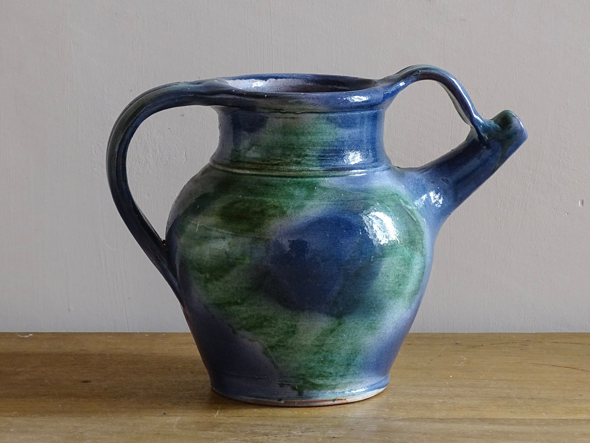 French vintage pottery jug or orjol with a soft blue and green glaze. Glazed terracotta water jug with spout and handle. 