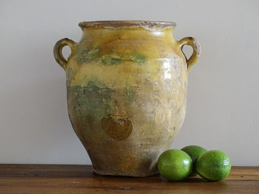 Large antique French confit pot with yellow glaze. Old terracotta pot with a rich patina and has touches of green over the mustard yellow.  Yellow confit jar with two handles, farmhouse pottery for a French country farmhouse decor.
