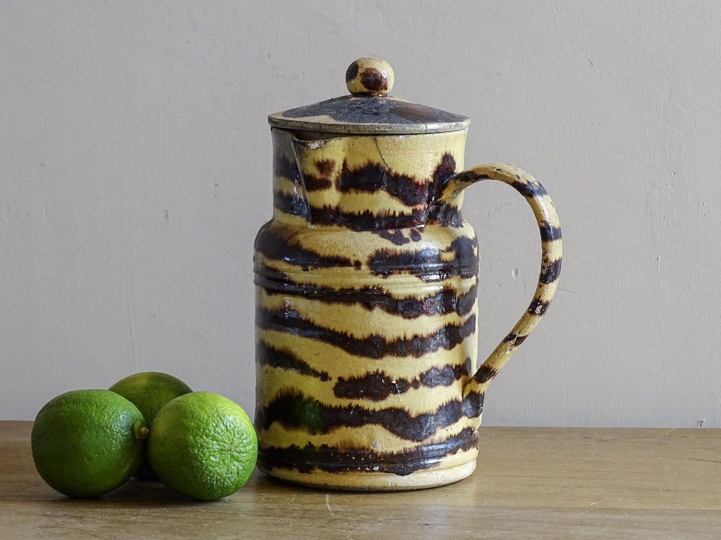 French antique ceramic pitcher with a lid, featuring a yellow and dark brown zebra-like patterned glaze, from the town of Dieulefit.