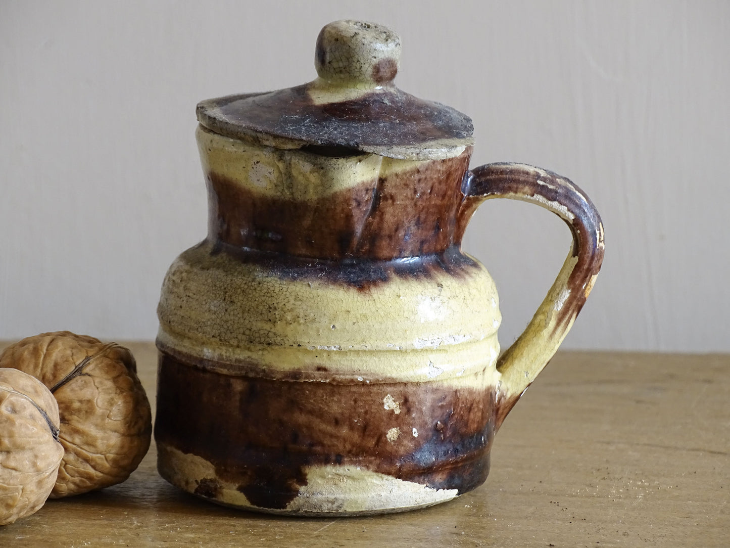 French antique pottery jug with a lid and brown and yellow glaze