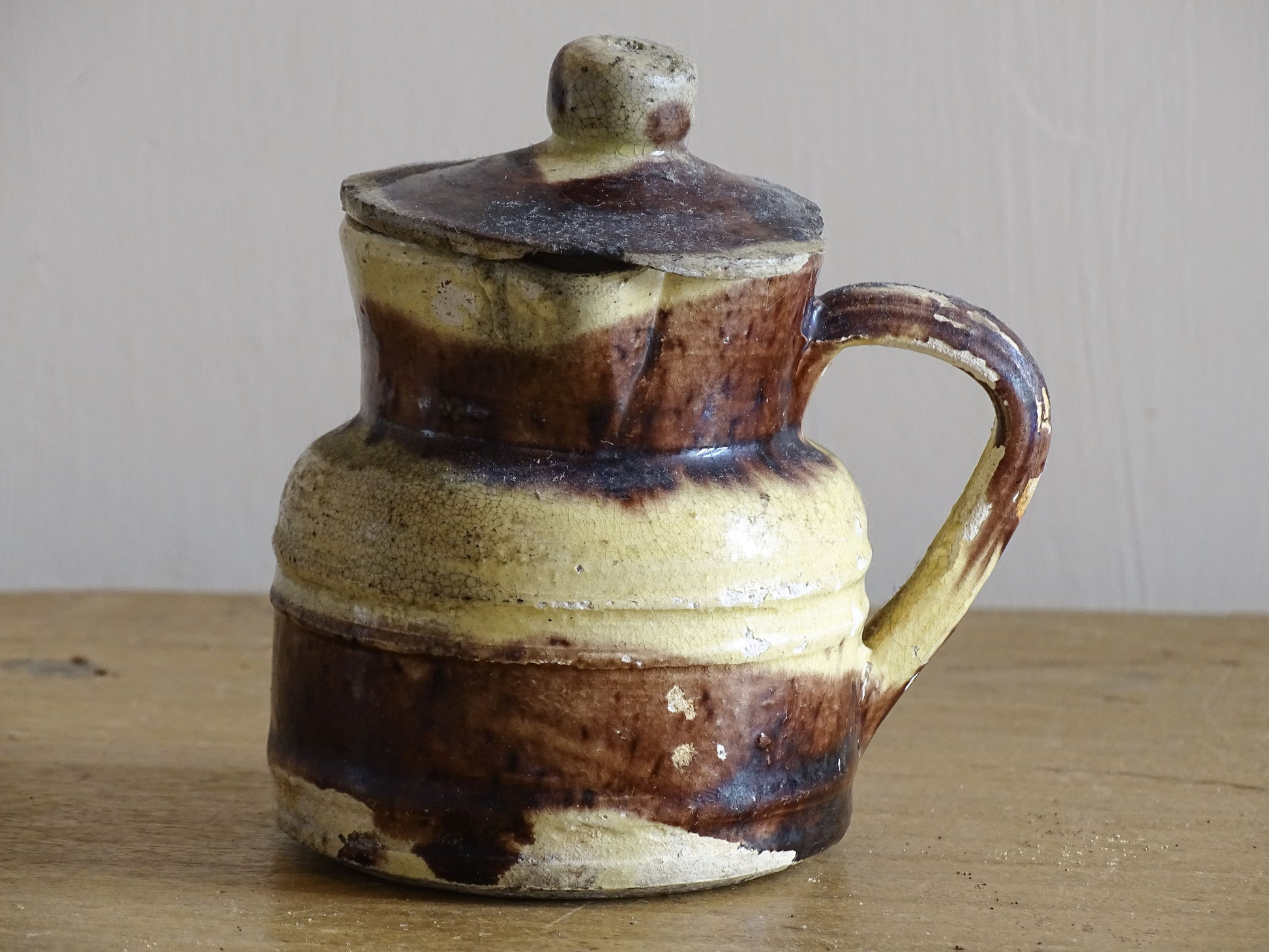 French antique pottery jug with a lid and brown and yellow glaze