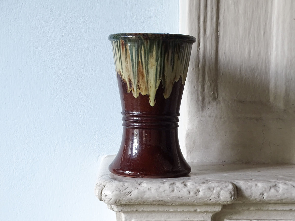 French antique ceramic vase with drip glaze, pictured on a country house fireplace