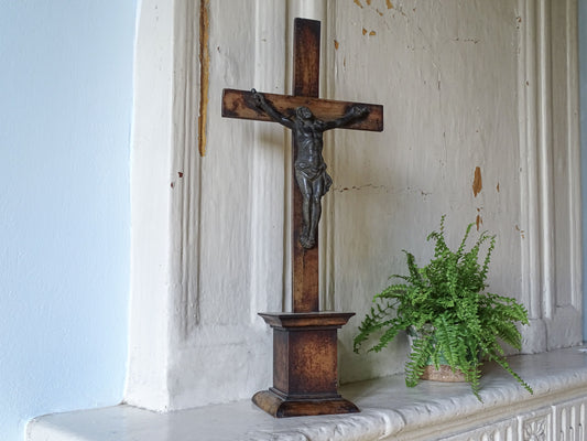 Large French antique wooden altar crucifix, displayed with a potted fern on a country house fireplace