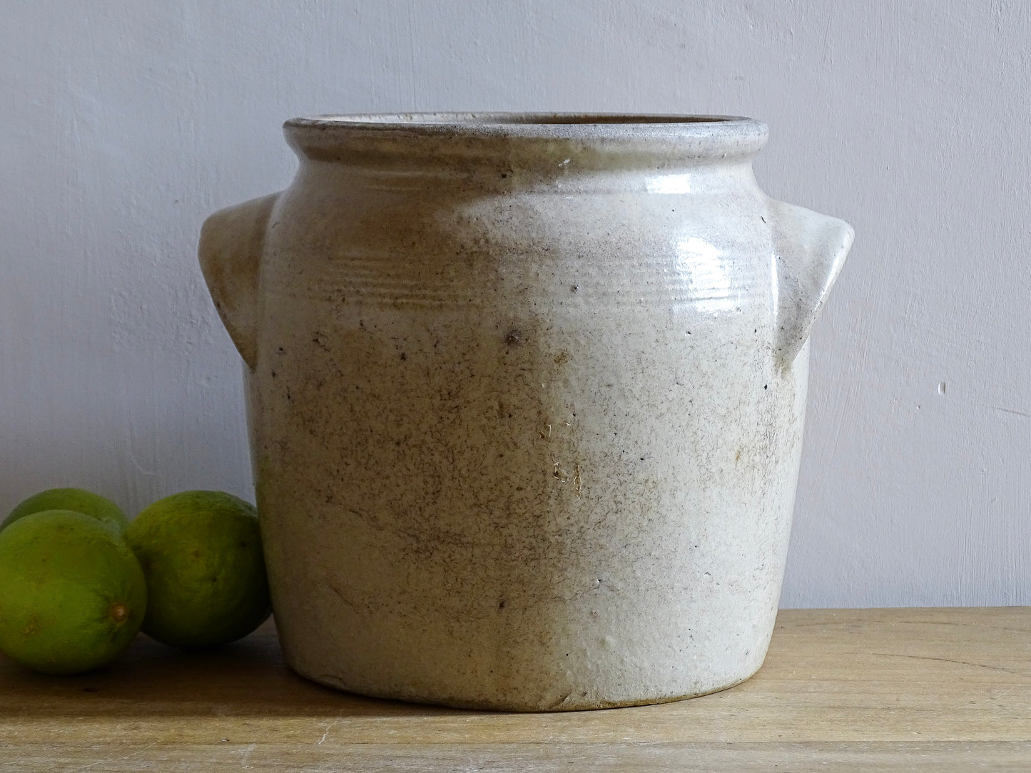 Rustic French antique stoneware confit jar. Glazed pottery cache pot is in a grey beige glaze for a French farmhouse style home.