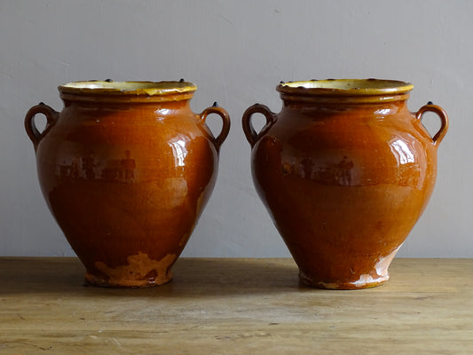 Pair of French antique confit pot vases with an orange glaze to the exterior and a yellow glaze to the interior for preserving food. Ceramic jars for rustic farmhouse decor. Orange and yellow glazed terracotta vases.