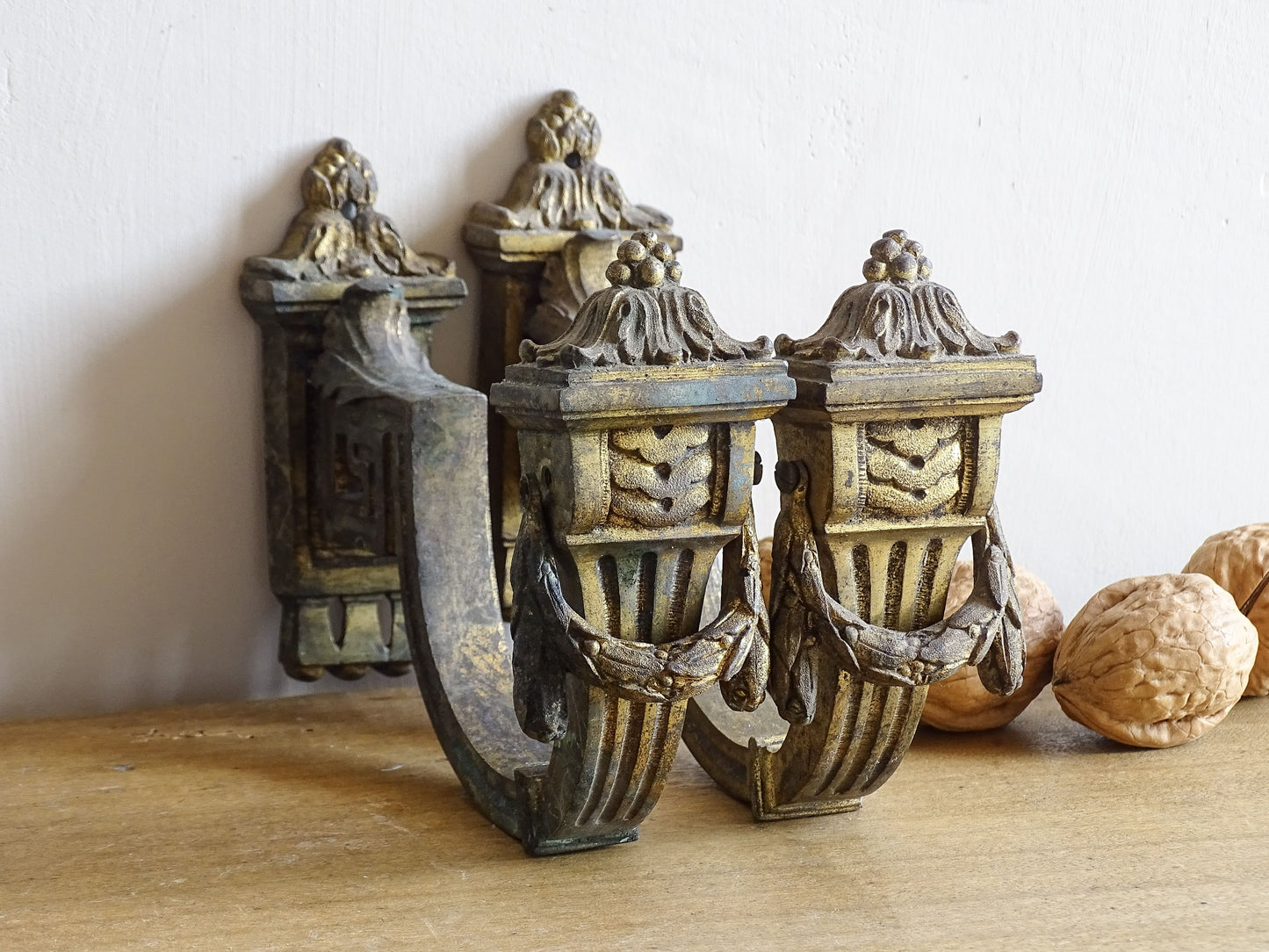 Pair of French antique curtain hooks in gilt bronze with intricate detailing. Empire style hooks with intricate acanthus leaf motifs and architectural elements.