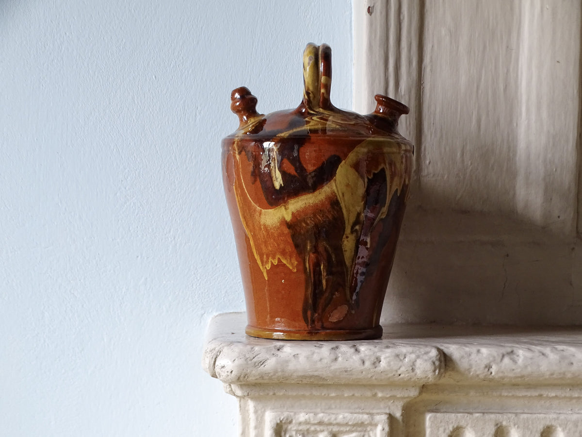 Spanish ceramic pitcher with jaspe glaze, pictured on a country house fireplace mantel