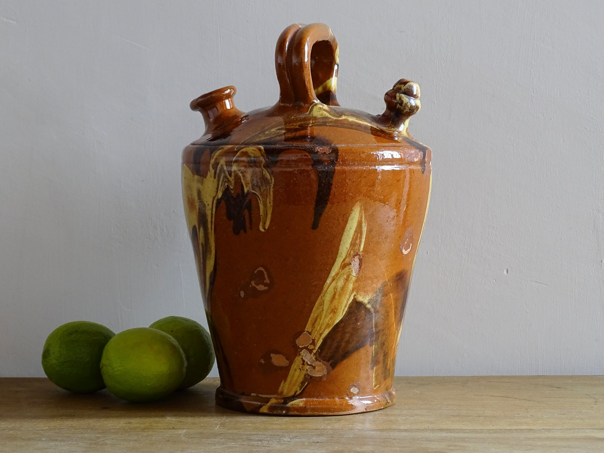 Rustic Catalan antique pottery gargoulette with a jaspé glaze in yellow or brown. The body of this marble glazed terracotta water jug has a sturdy handle to the top and two spouts.