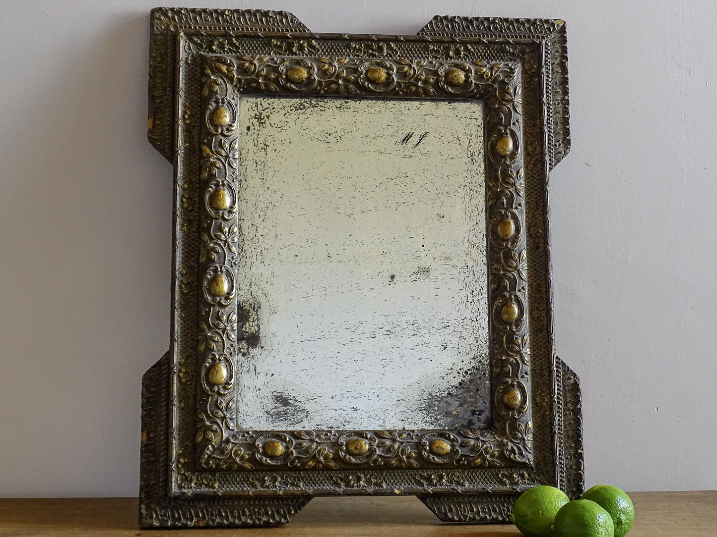 French antique gold decorative mirror with ornate frame on a wooden surface