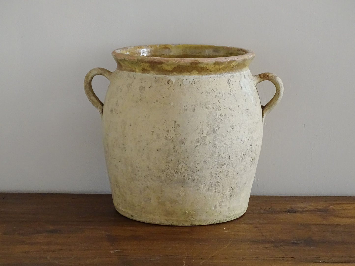French antique confit pot with a yellow glazed interior and unglazed terracotta exterior.