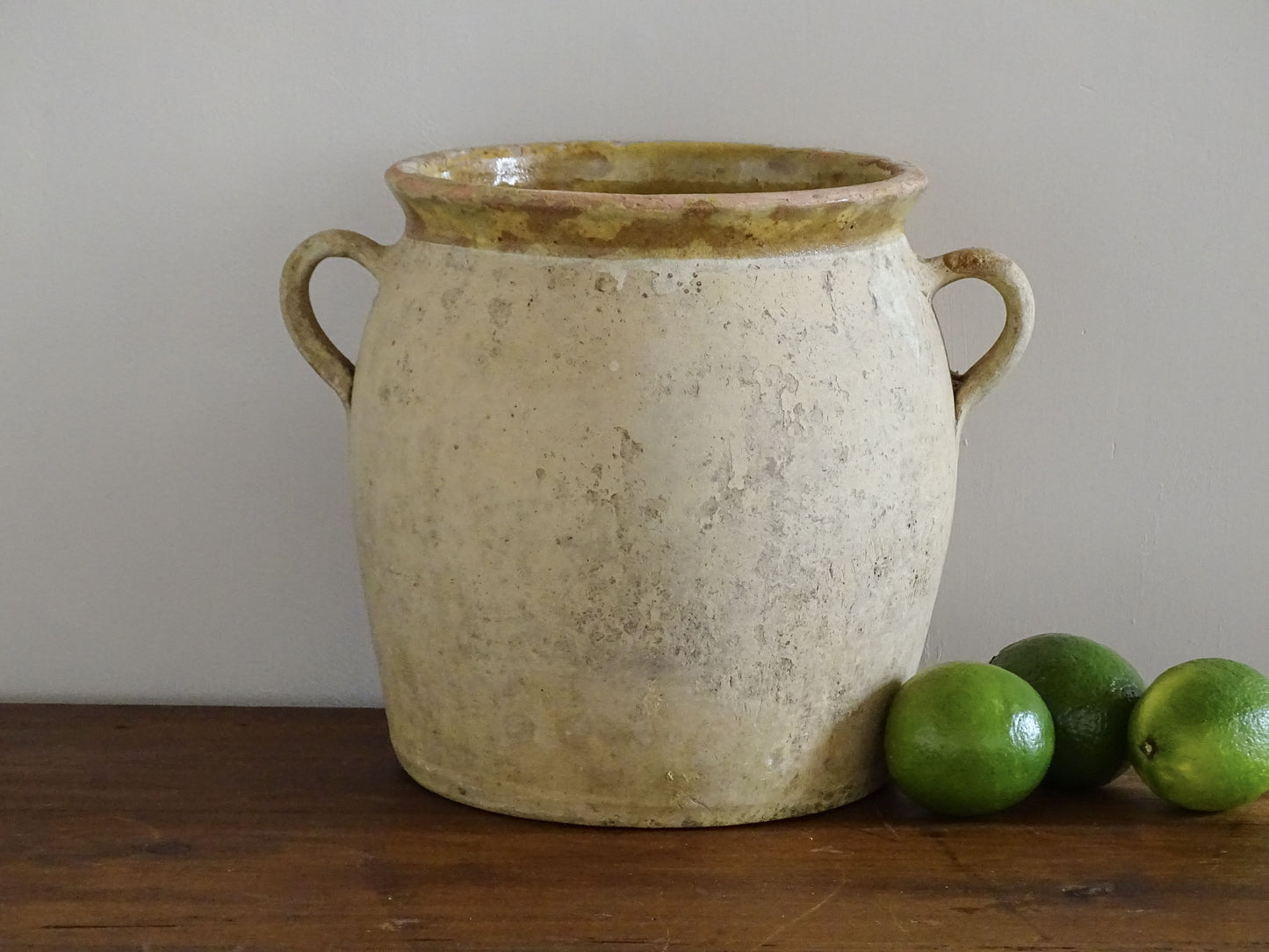 French antique confit pot with a yellow glazed interior and unglazed terracotta exterior.