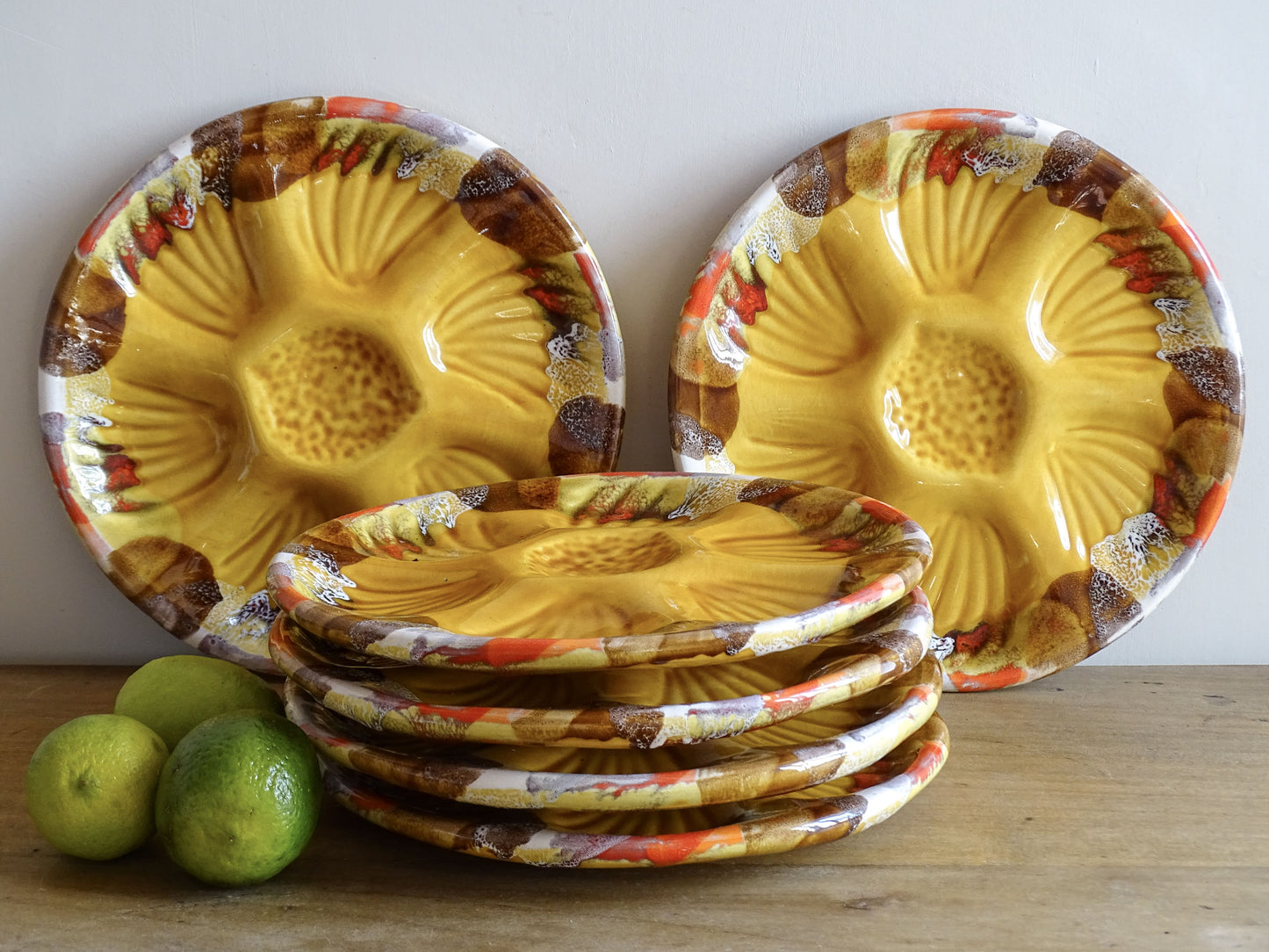 French vintage Vallauris pottery oyster plates with an ochre yellow glaze and a freeform edge in brown, red and white.
