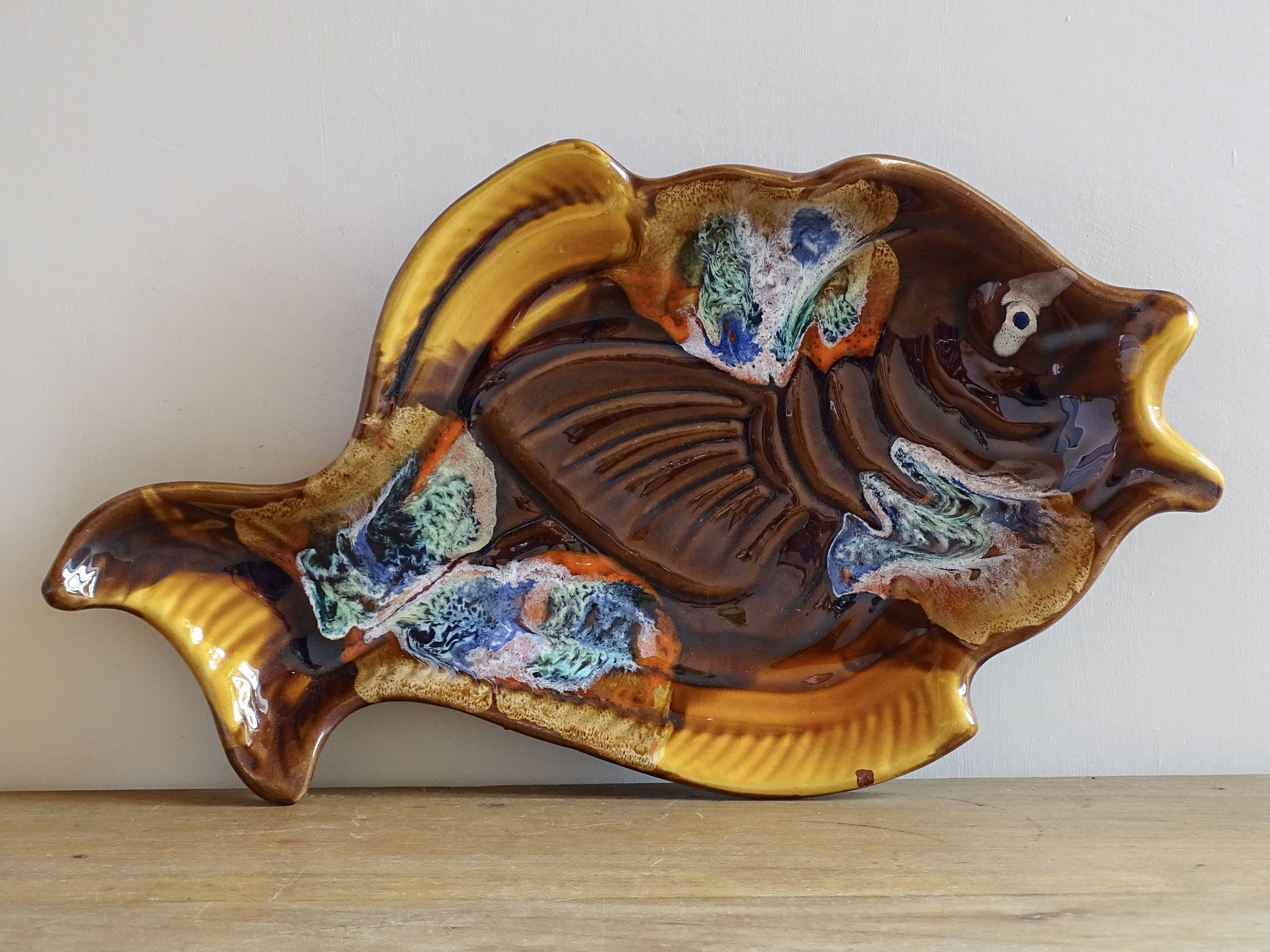 French vintage Vallauris pottery fish plate. It is glazed in brown with details in blue and red