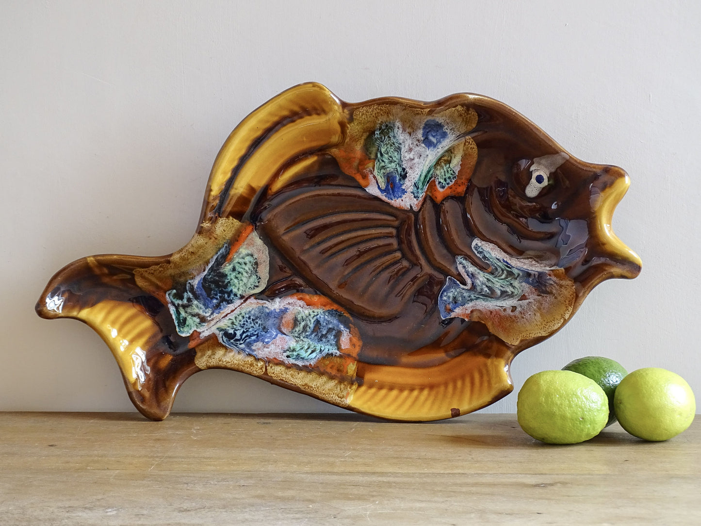 French vintage Vallauris pottery fish plate. It is glazed in brown with details in blue and red