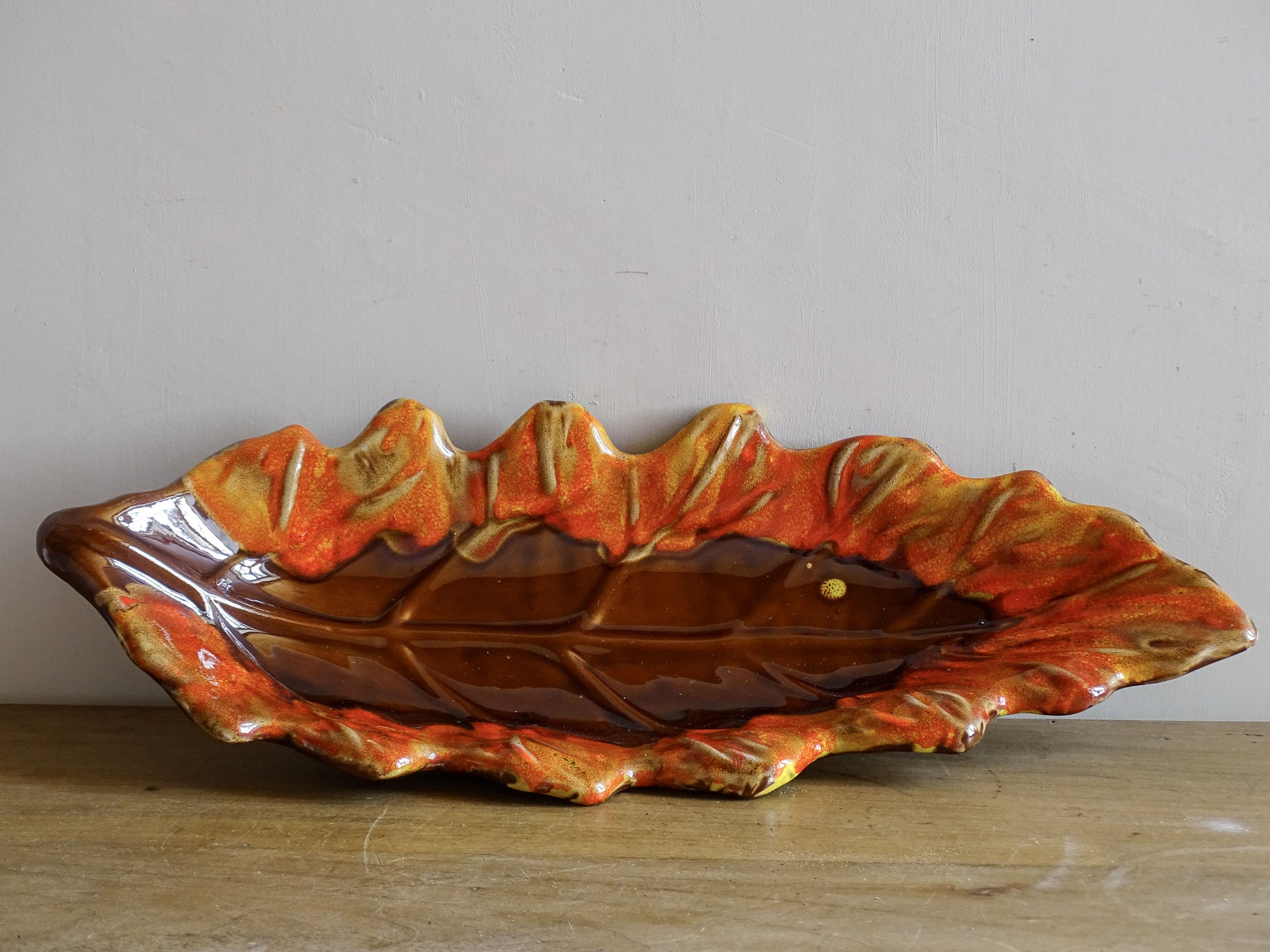 French vintage ceramic bowl in the shape of a leaf with red and orange glaze. Vallauris pottery