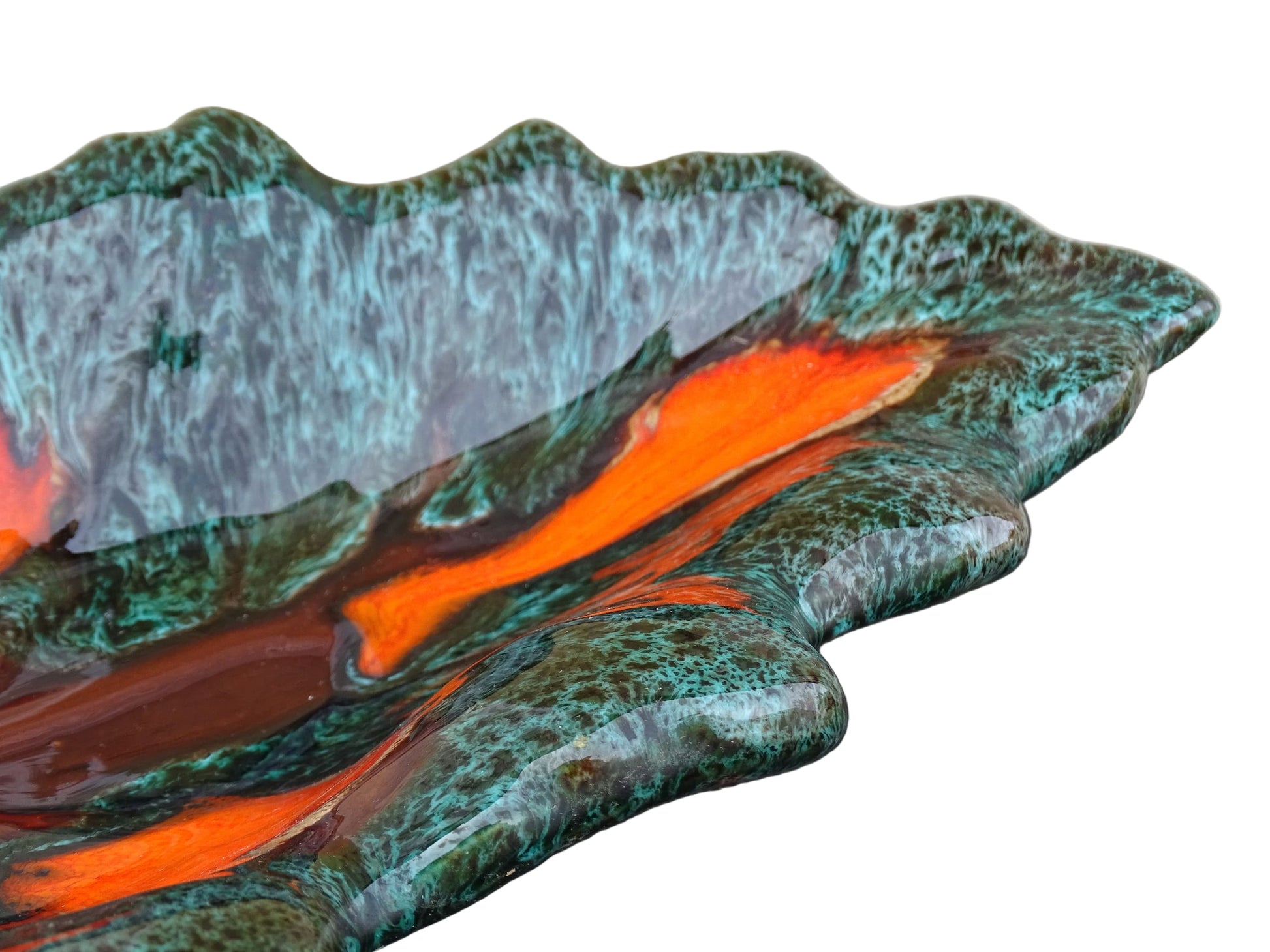 Large French vintage Vallauris ceramic bowl in the shape of a leaf. It is glazed with a dark green with details in brown and orange.