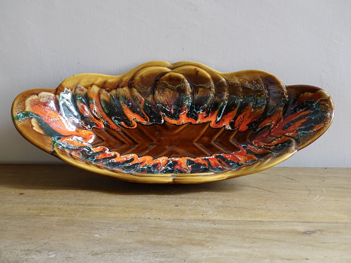 French vintage Vallauris pottery bowl with a brown glaze and red and green detailing. The ceramic centrepiece has a geometric design to the centre and a free flow design to the edge.