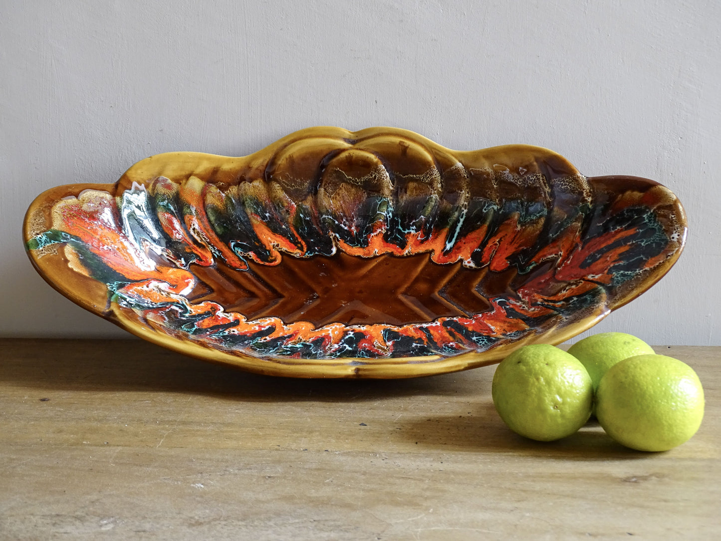 French vintage Vallauris pottery bowl with a brown glaze and red and green detailing. The ceramic centrepiece has a geometric design to the centre and a free flow design to the edge.