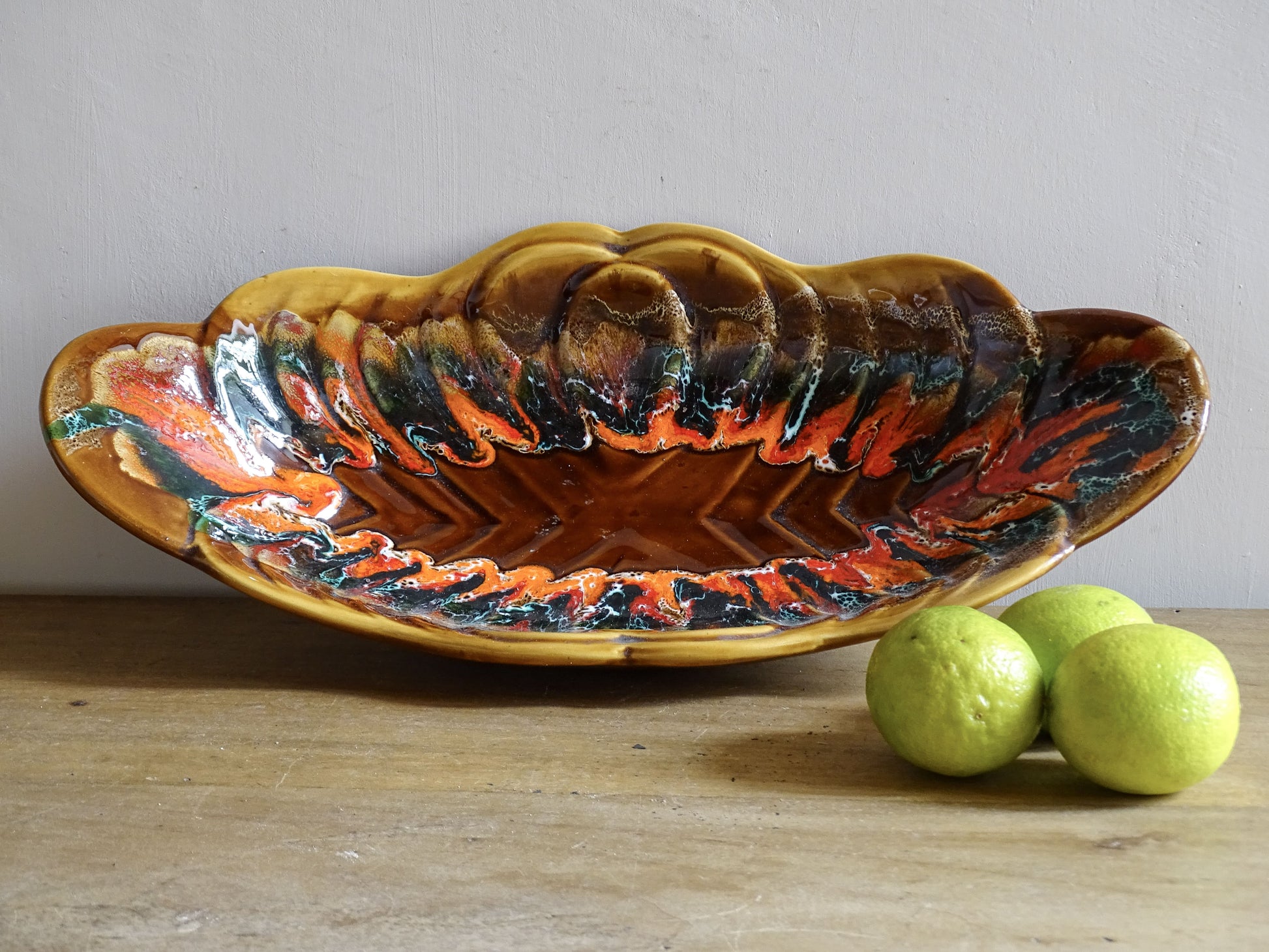 French vintage Vallauris pottery bowl with a brown glaze and red and green detailing. The ceramic centrepiece has a geometric design to the centre and a free flow design to the edge.