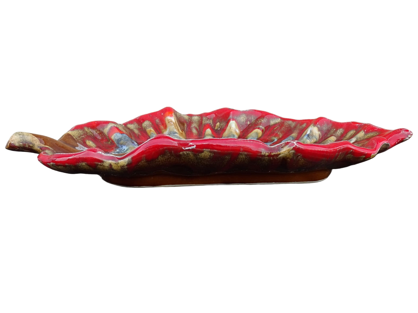 French vintage Vallauris ceramic dish in a leaf design. The pottery dish is glazed in red with details in pale blue, yellow and brown