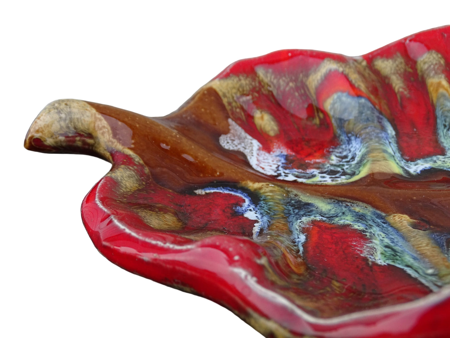 French vintage Vallauris ceramic dish in a leaf design. The pottery dish is glazed in red with details in pale blue, yellow and brown