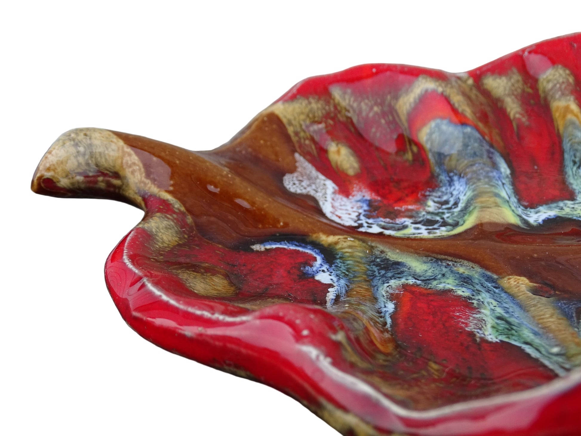 French vintage Vallauris ceramic dish in a leaf design. The pottery dish is glazed in red with details in pale blue, yellow and brown