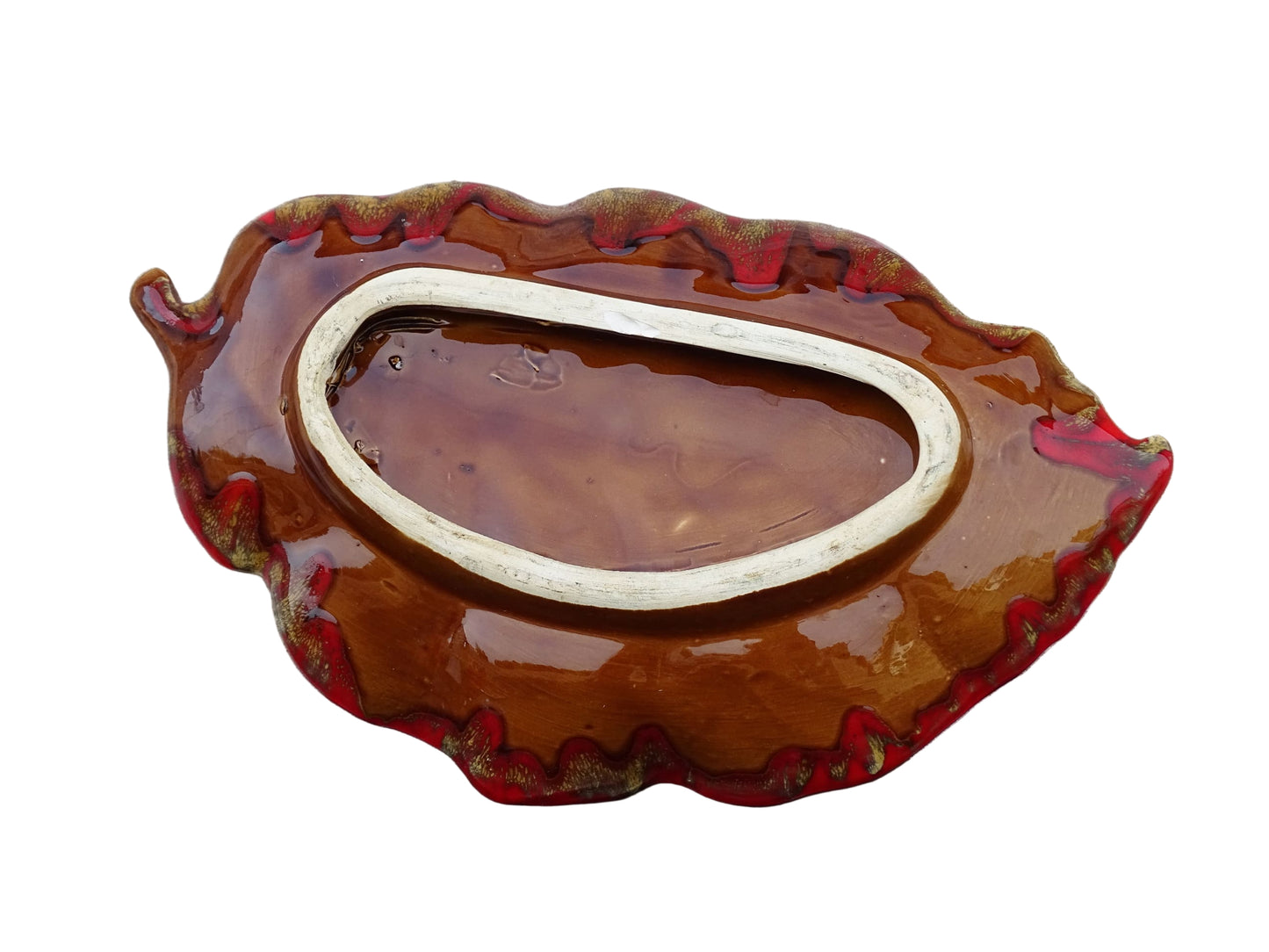 French vintage Vallauris ceramic dish in a leaf design. The pottery dish is glazed in red with details in pale blue, yellow and brown