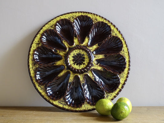 Large French vintage Vallauris ceramic oyster plate by Maruis Giuge. Serving platter with space for twelve oysters. It has a yellow and brown glaze.