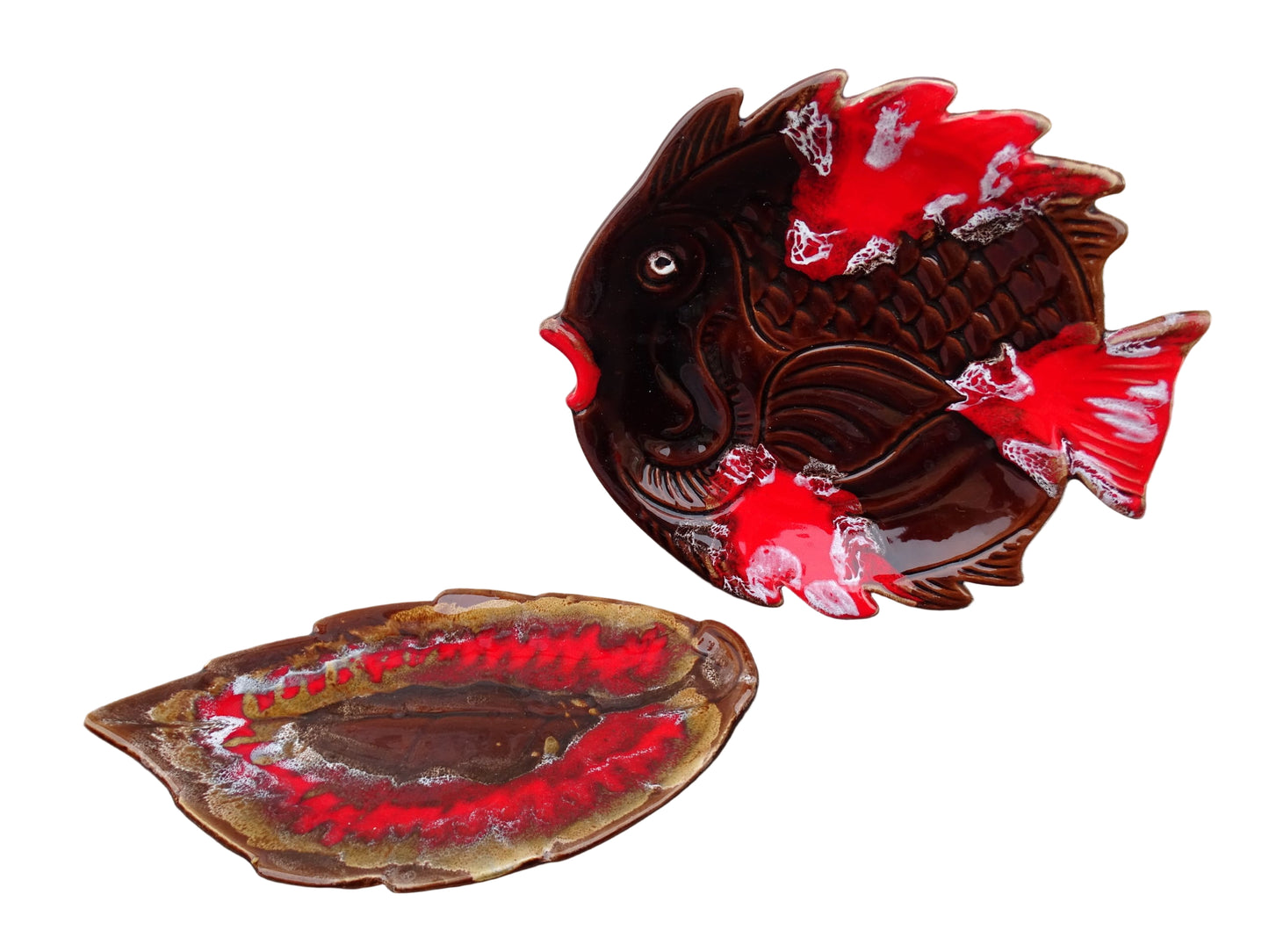 French vintage French Vallauris pottery leaf plate with a brown and red glaze alongside a vintage pottery fish plate.