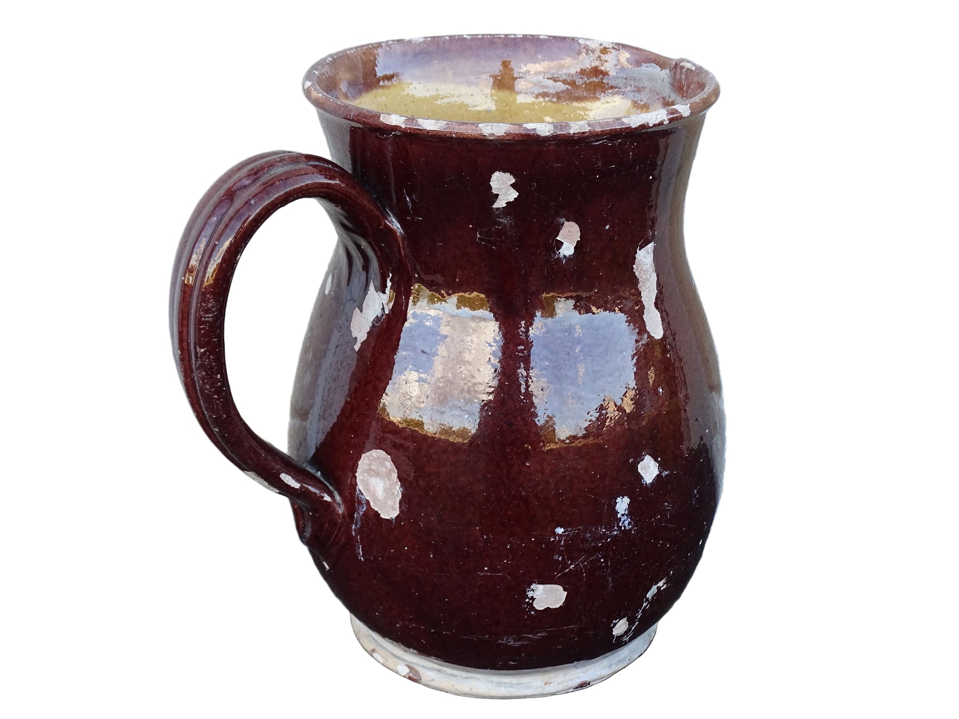 Brown French antique pottery pitcher with yellow glaze interior. Timeworn ceramic jug with handle and spout.