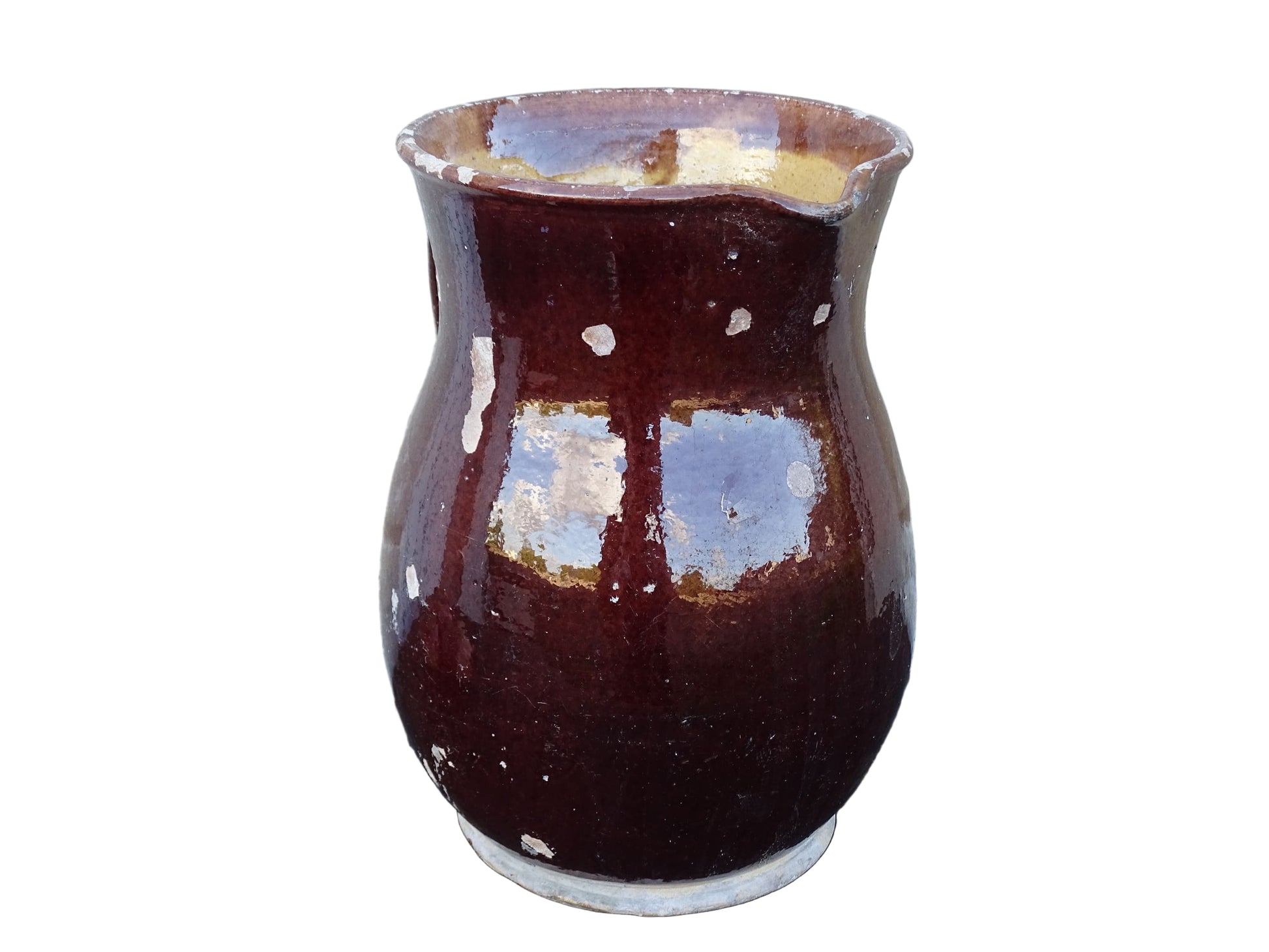 Brown French antique pottery pitcher with yellow glaze interior. Timeworn ceramic jug with handle and spout.