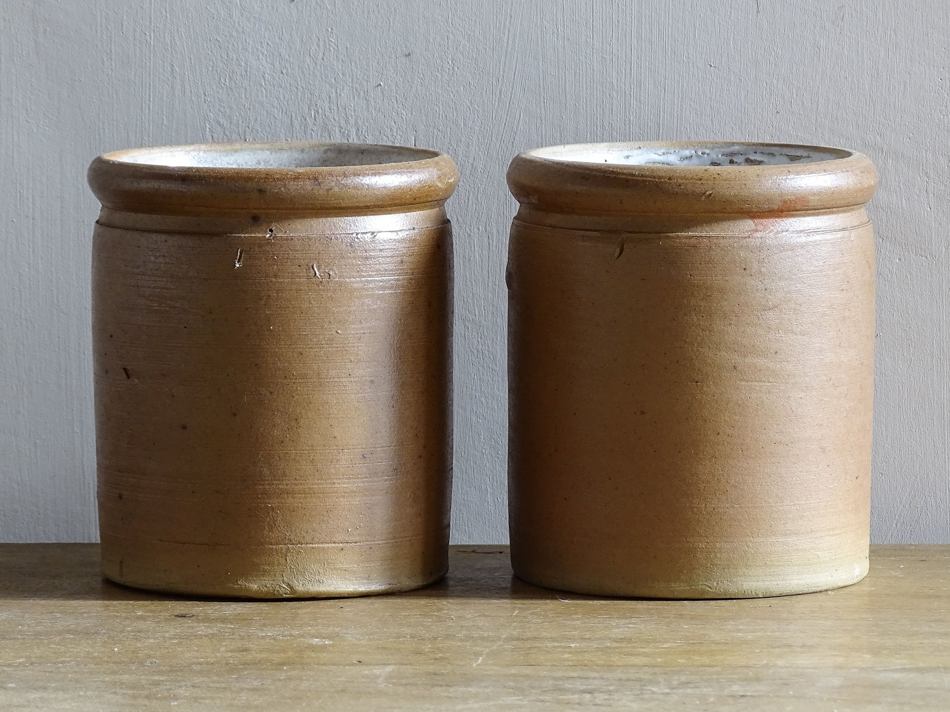 Rustic pair of French vintage stoneware pots with a brown, salt glaze. Old pottery jars with a ribbed texture.