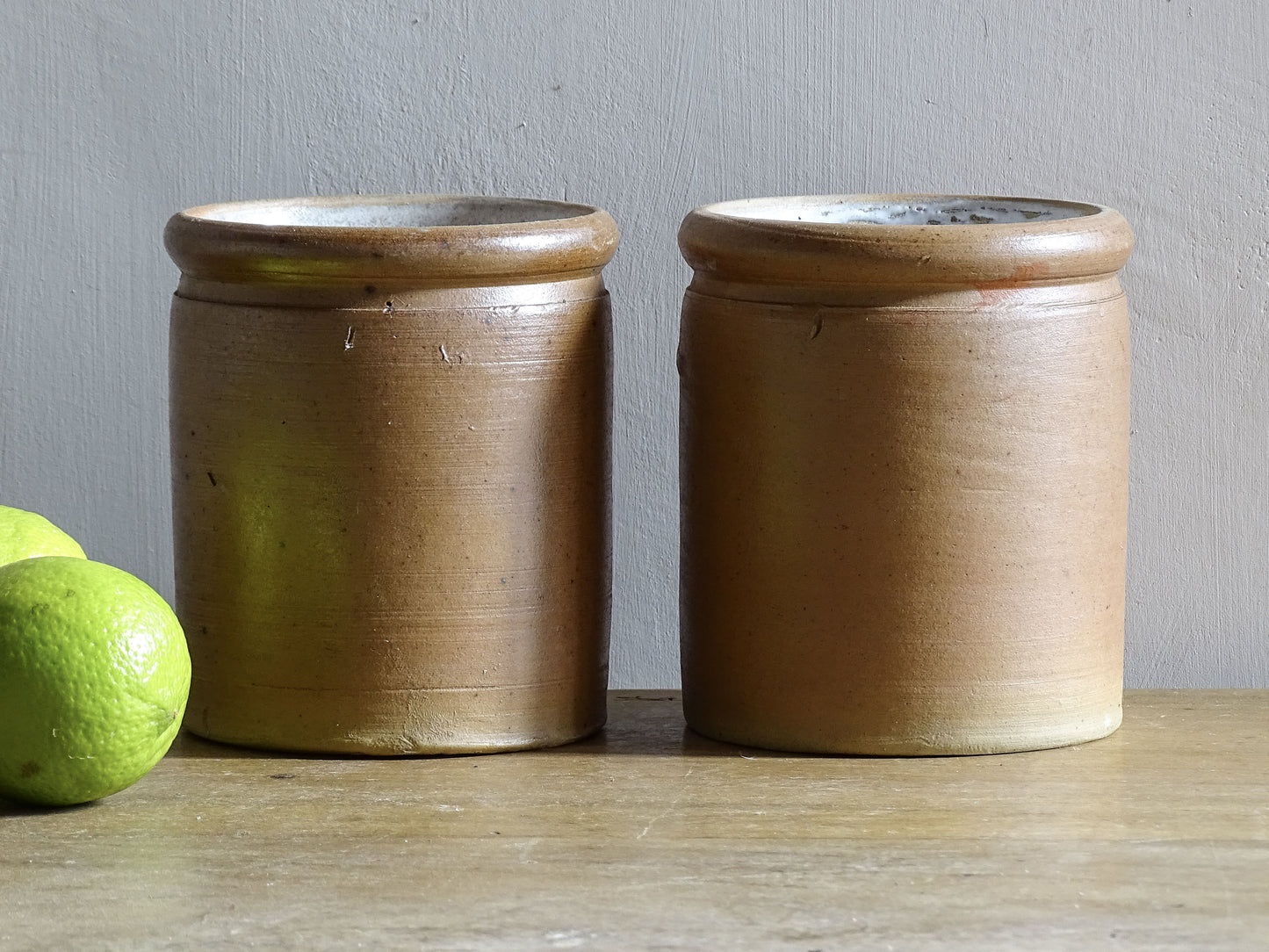 Rustic pair of French vintage stoneware pots with a brown, salt glaze. Old pottery jars with a ribbed texture.
