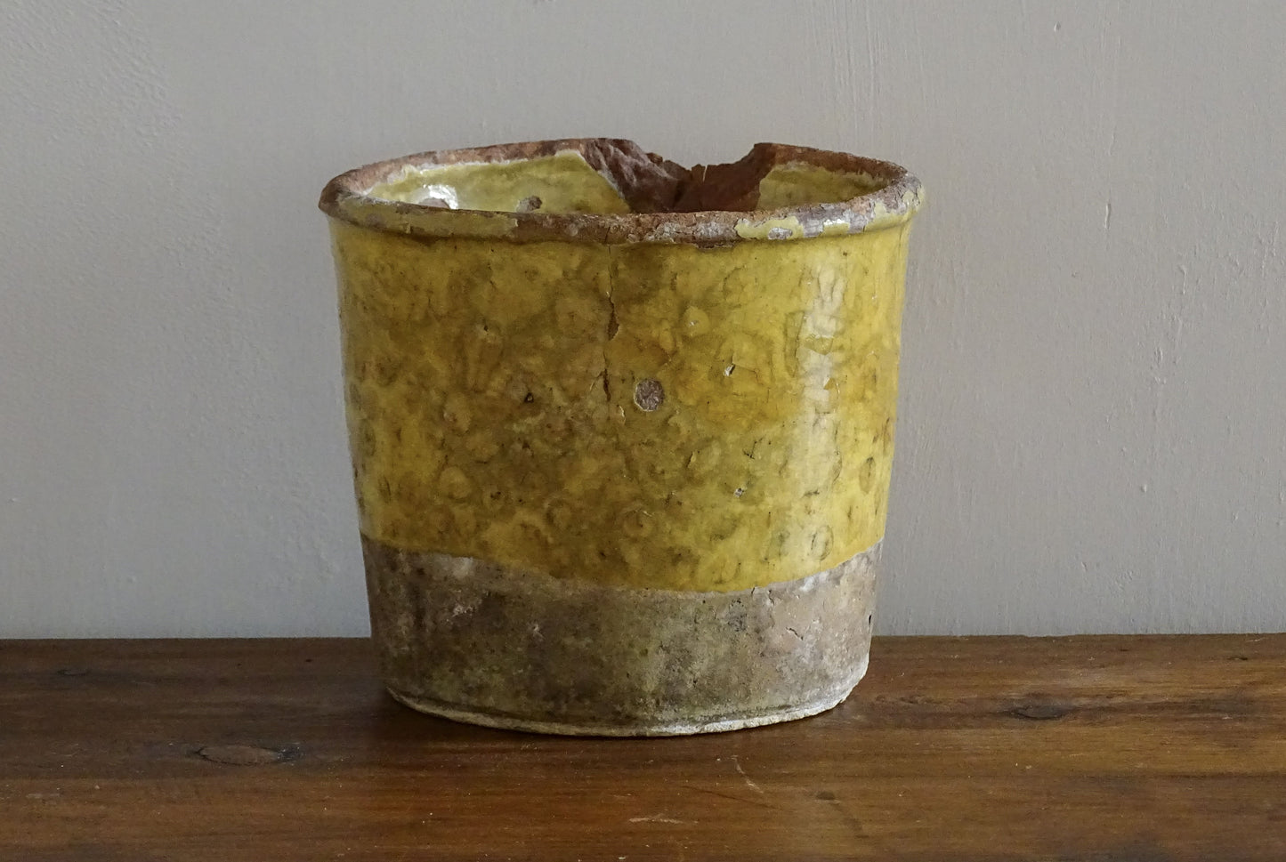 French antique yellow confit pot with patina. Aged earthenware pot with glaze.