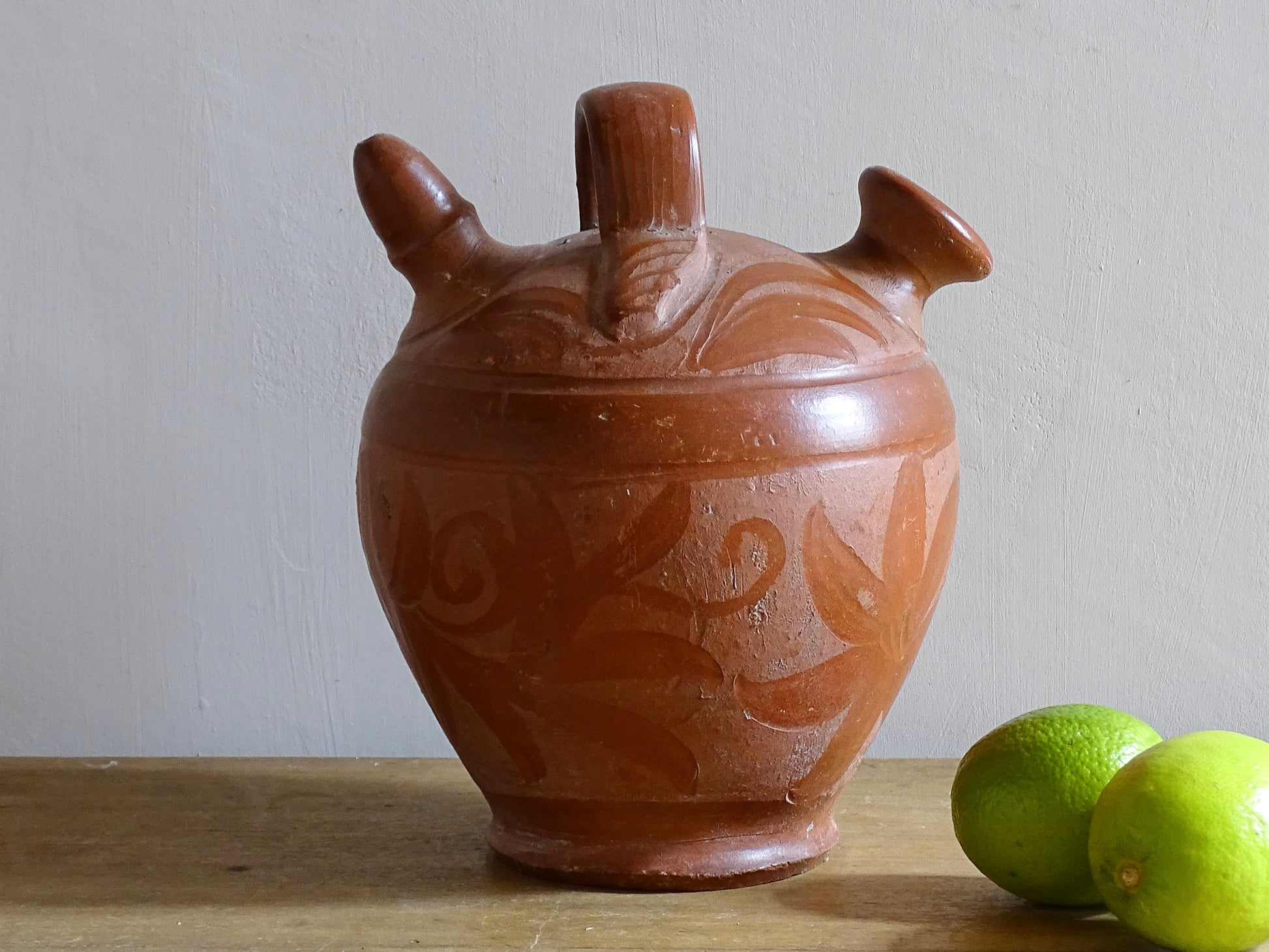 French vintage pottery gargoulette in red with floral detailing. Ceramic jug with handle and two spouts. 