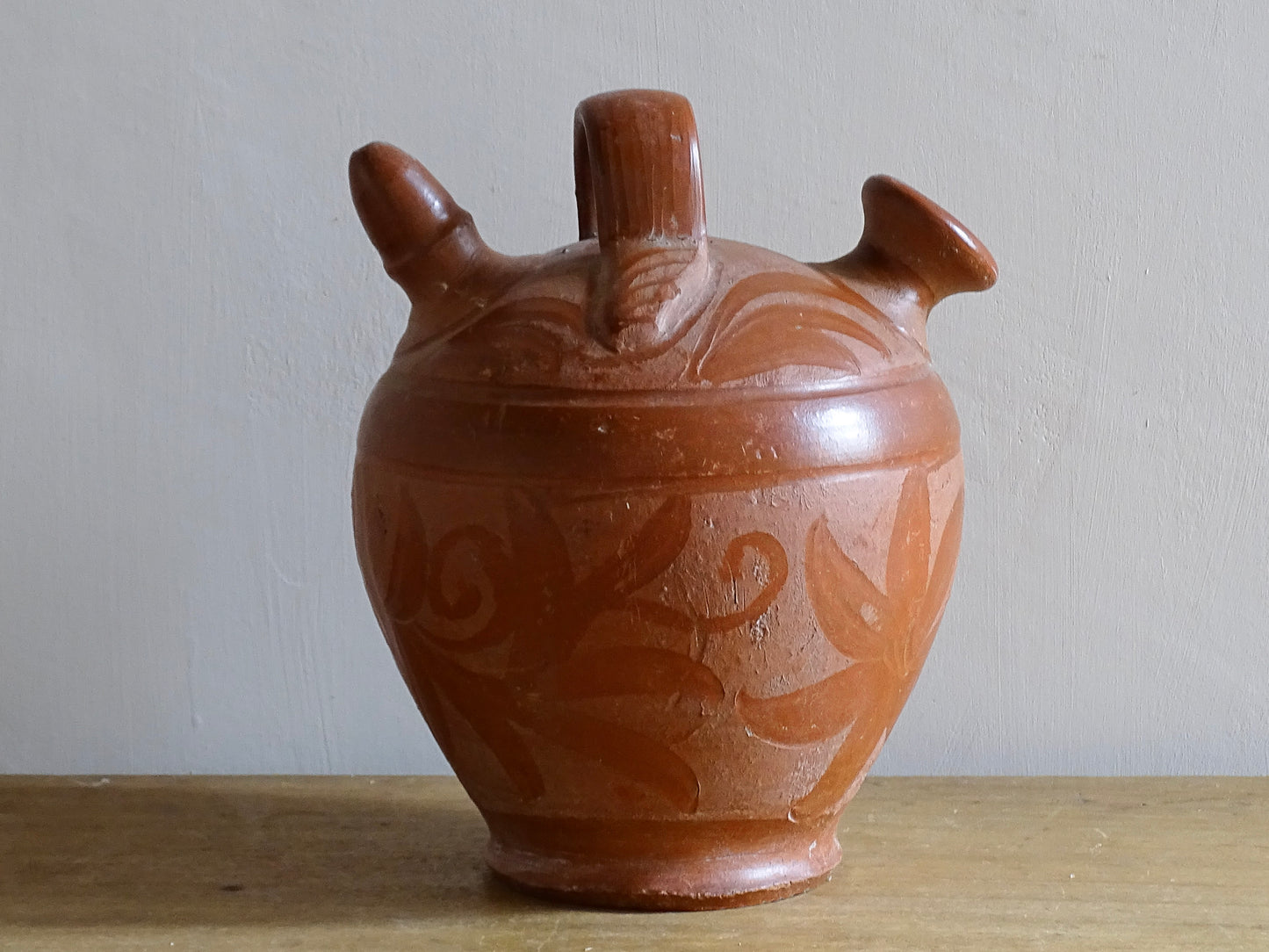 French vintage pottery gargoulette in red with floral detailing. Ceramic jug with handle and two spouts. 