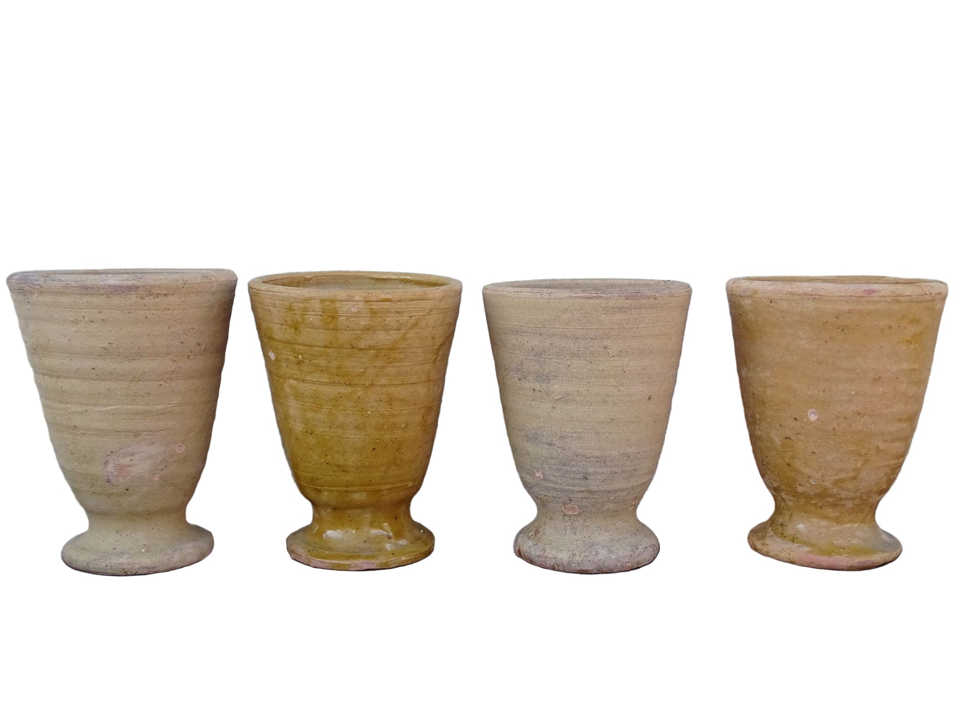 Set of four French vintage terracotta goblets. Of the four pottery cups, one has a beautiful yellow glaze, another is partially glazed and the other two are unglazed.