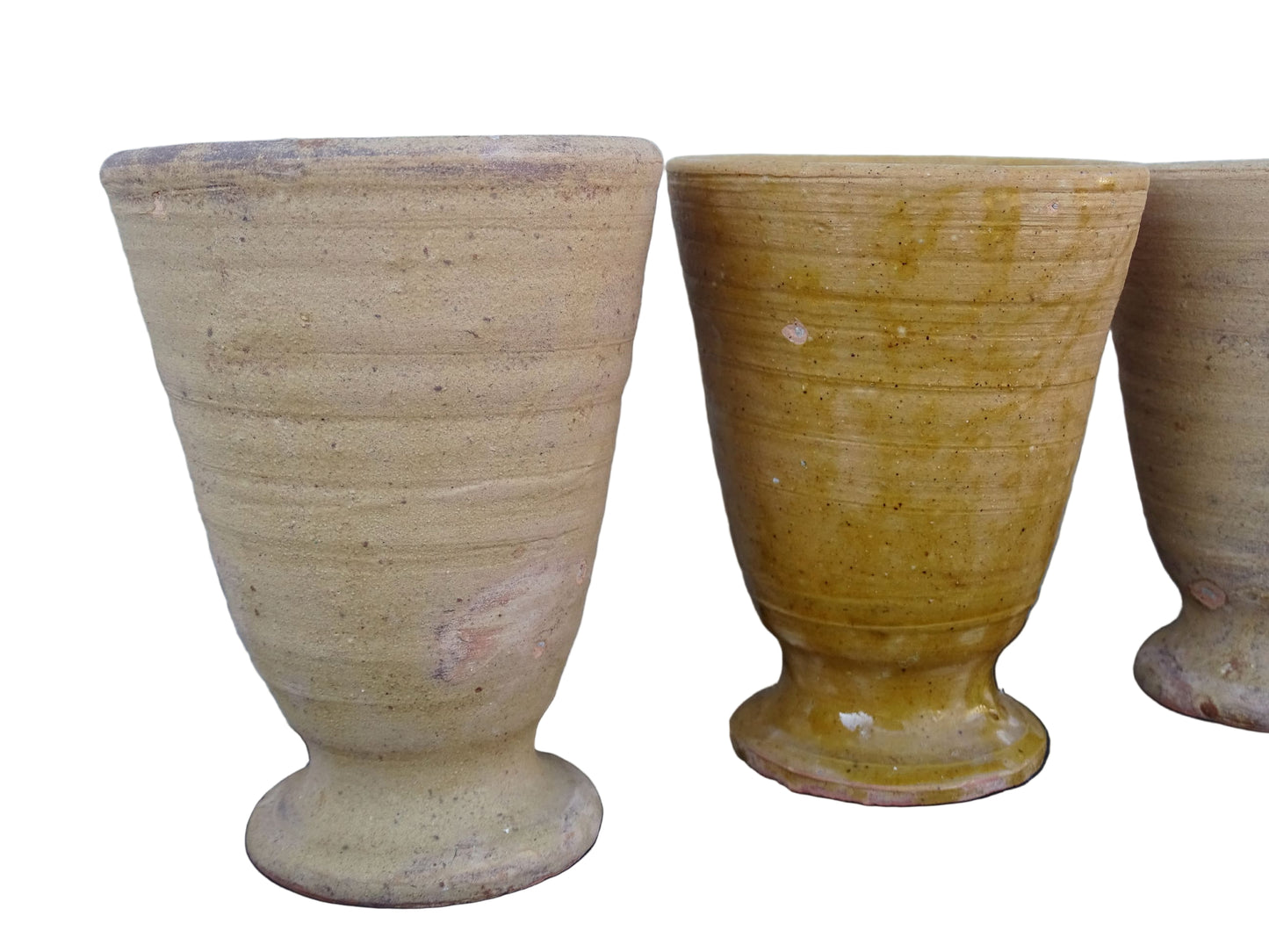 Set of four French vintage terracotta goblets. Of the four pottery cups, one has a beautiful yellow glaze, another is partially glazed and the other two are unglazed.