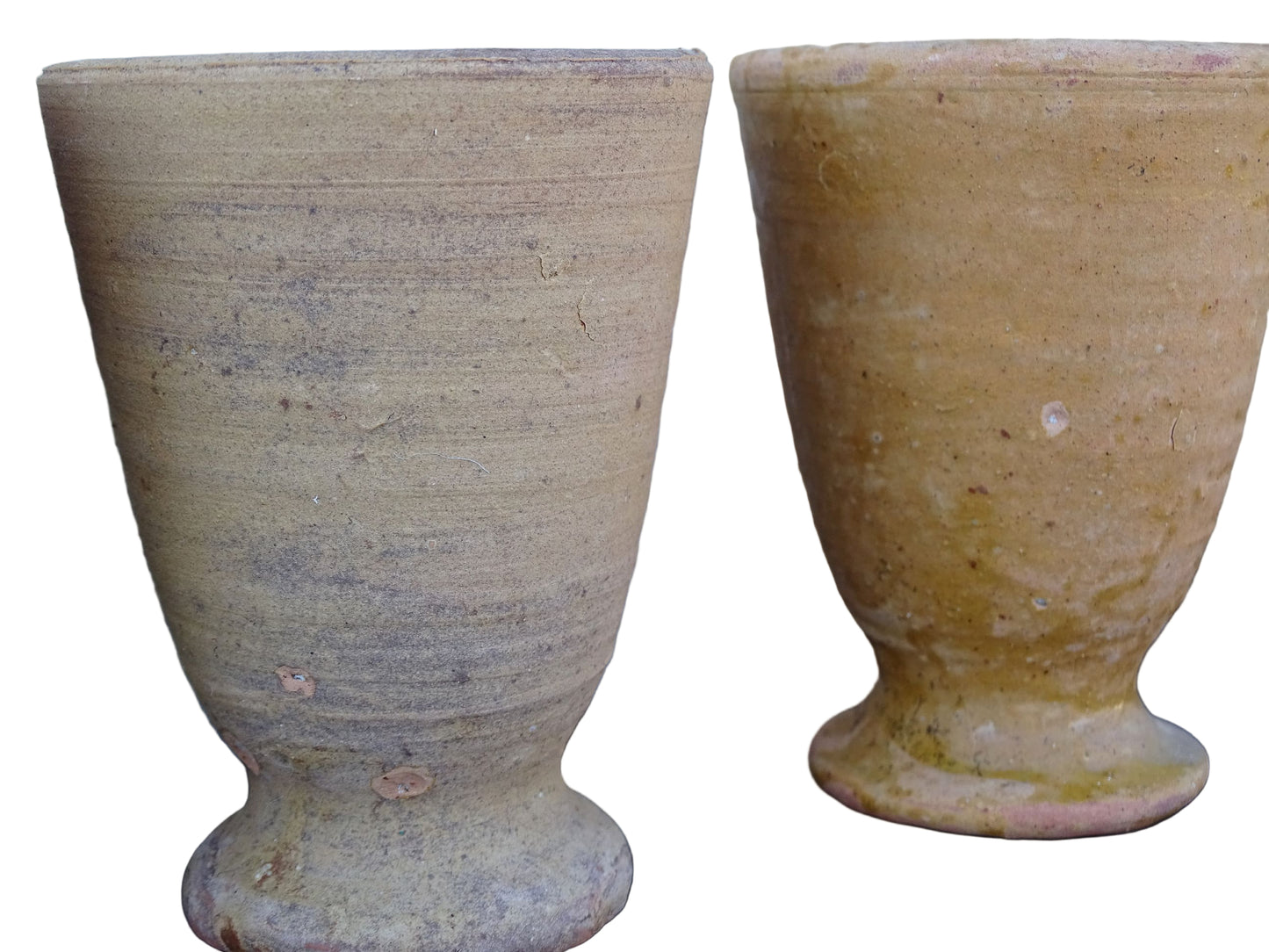 Set of four French vintage terracotta goblets. Of the four pottery cups, one has a beautiful yellow glaze, another is partially glazed and the other two are unglazed.