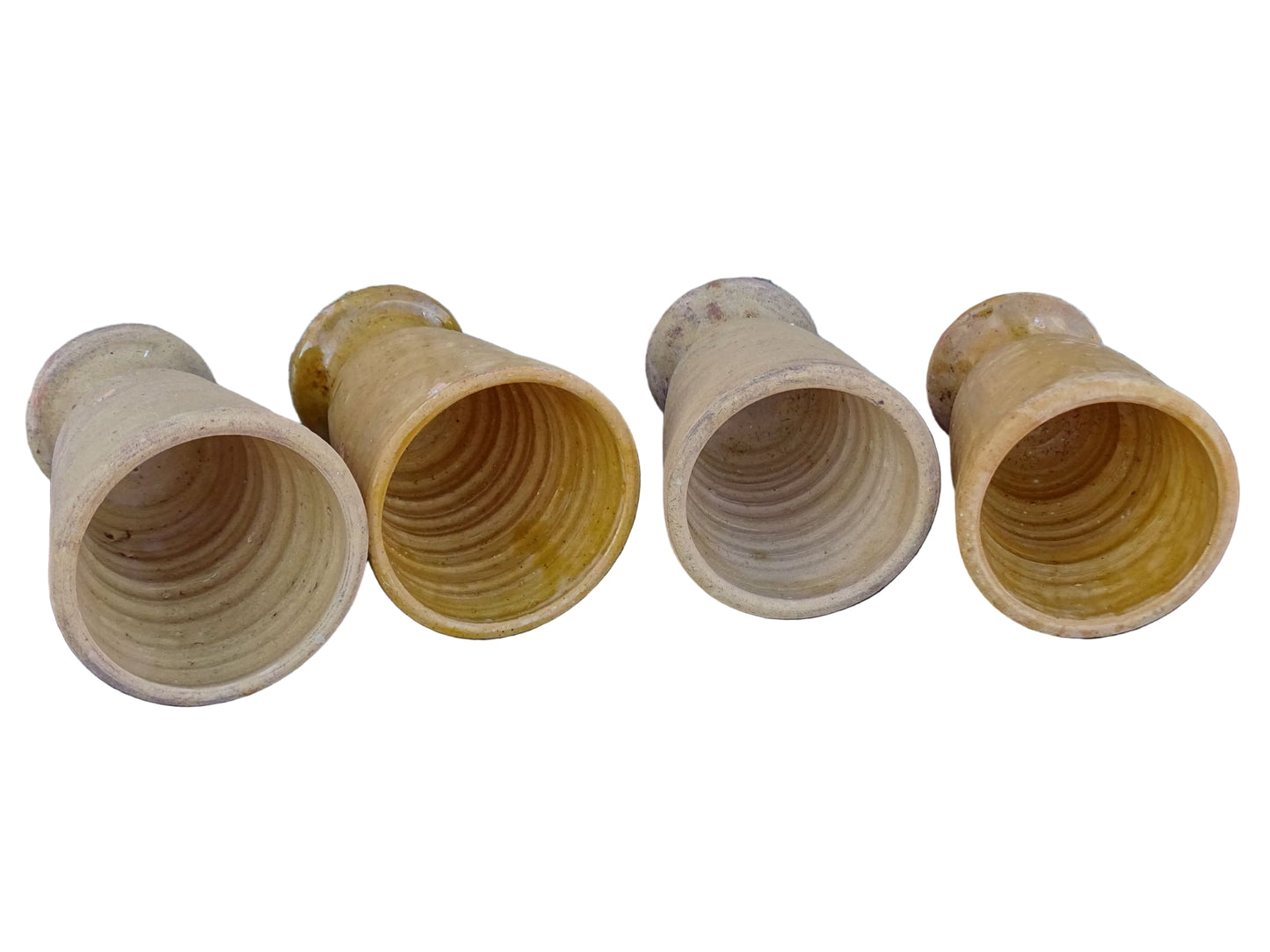 Set of four French vintage terracotta goblets. Of the four pottery cups, one has a beautiful yellow glaze, another is partially glazed and the other two are unglazed.