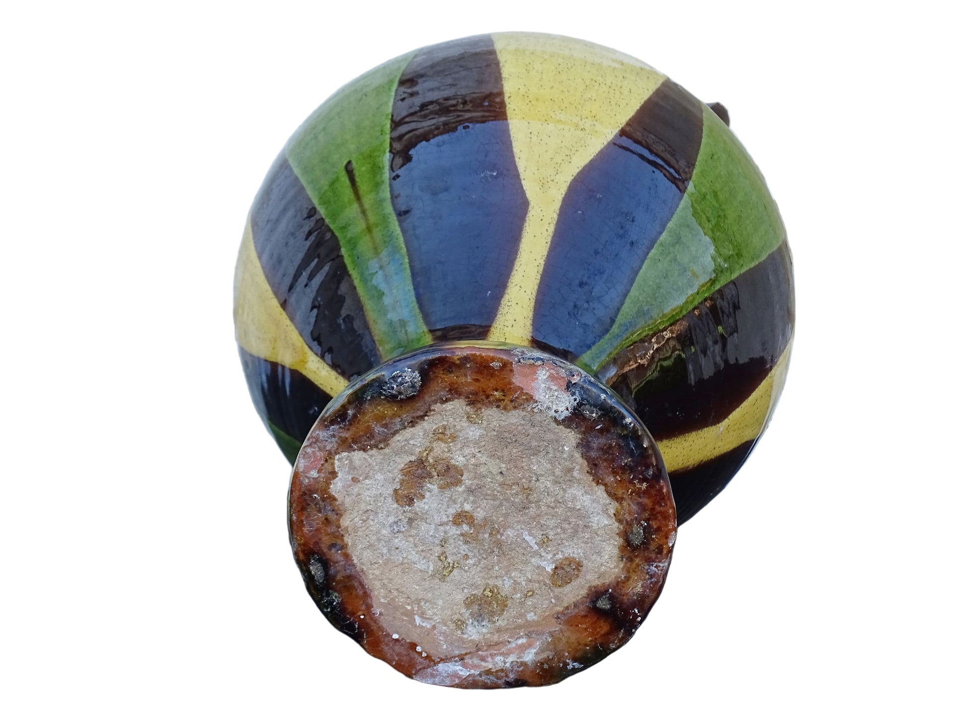 French antique pitcher or gargoulette. Terracotta jug with a green and yellow striped glaze on a dark brown background. It has a curved shape with a round handle to the top and two spouts.